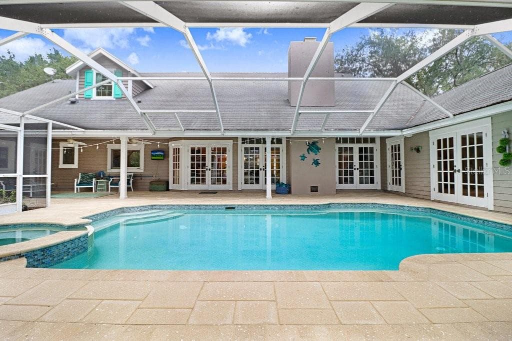Pool/Spa view showcasing wrap around Hacienda floor plan with French doors. - 1976 DUNLOE CIR, DUNEDIN