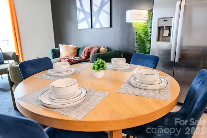 The bright, open-concept living and dining area is filled with natural light and offers the perfect space for everyday living, entertaining, and seamless access to the private balcony. - 3019 Jolene Court, Charlotte