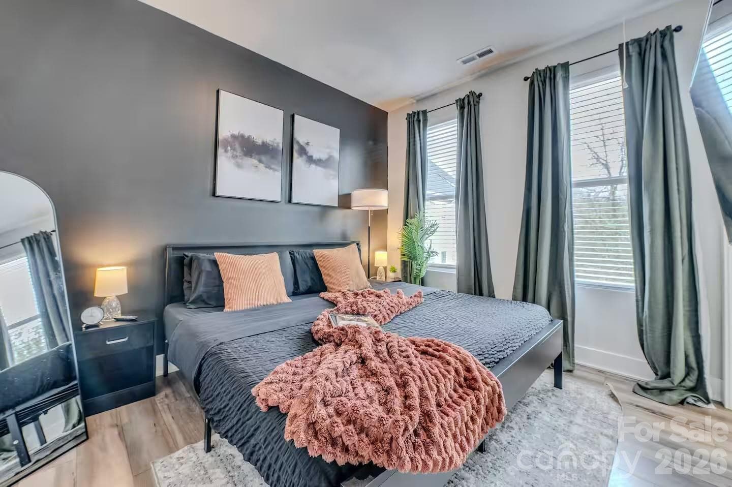 The spacious primary suite offers a peaceful retreat with abundant natural light, soaring ceilings, designer accent wall, and plenty of room to relax and unwind. - 3019 Jolene Court, Charlotte