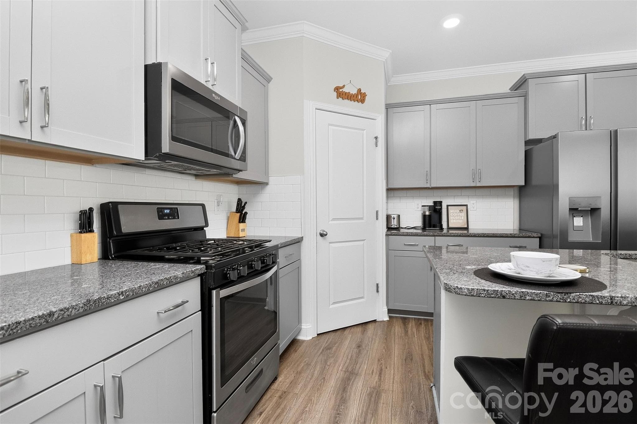 Chef's kitchen features gas range, huge island with breakfast bar, corner pantry, granite countertops, subway tile backsplash, abundant cabinetry - Clover