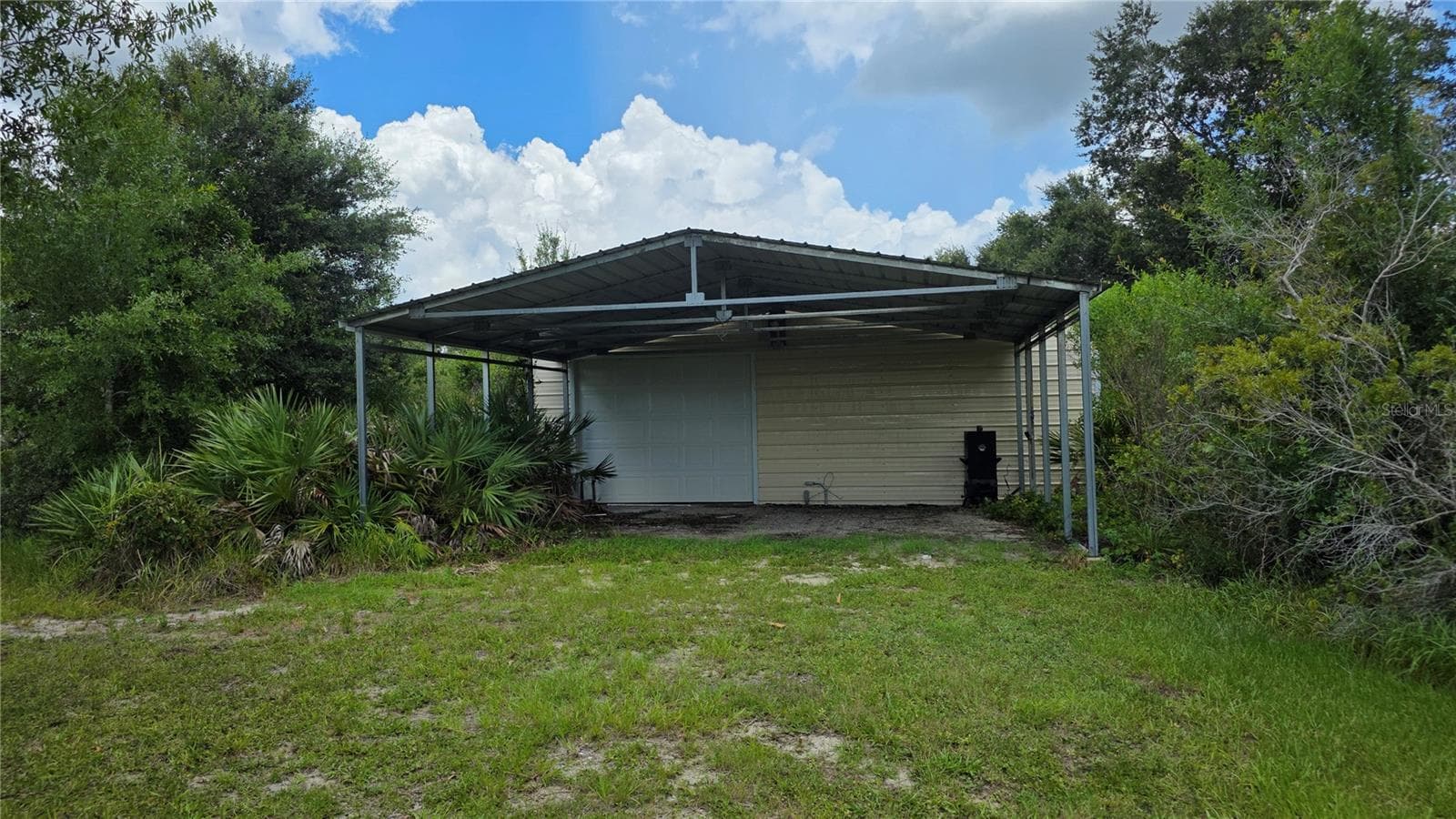 Covered exterior workspace ideal for projects, storage, or equipment. - 1210 408TH CT E, MYAKKA CITY
