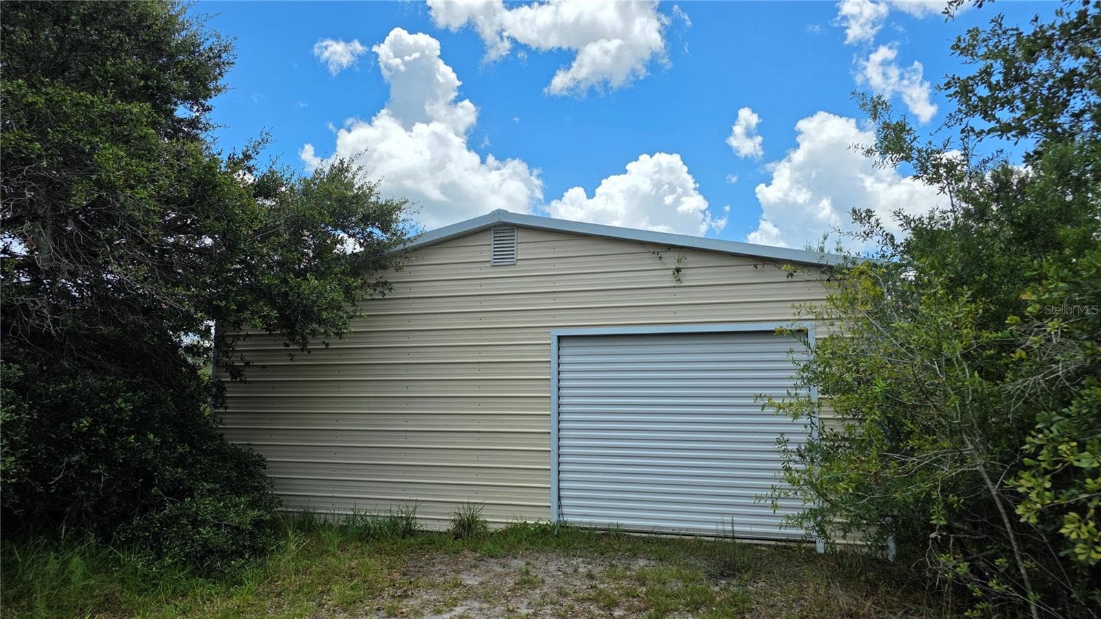 Drive-through garage design offers exceptional flexibility and access. - 1210 408TH CT E, MYAKKA CITY