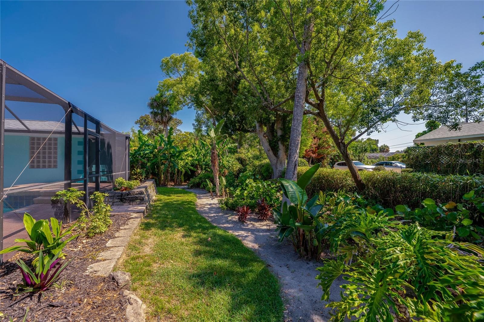 Lush tropical landscaping behind pool - 697 JOHN ANDERSON DR, ORMOND BEACH