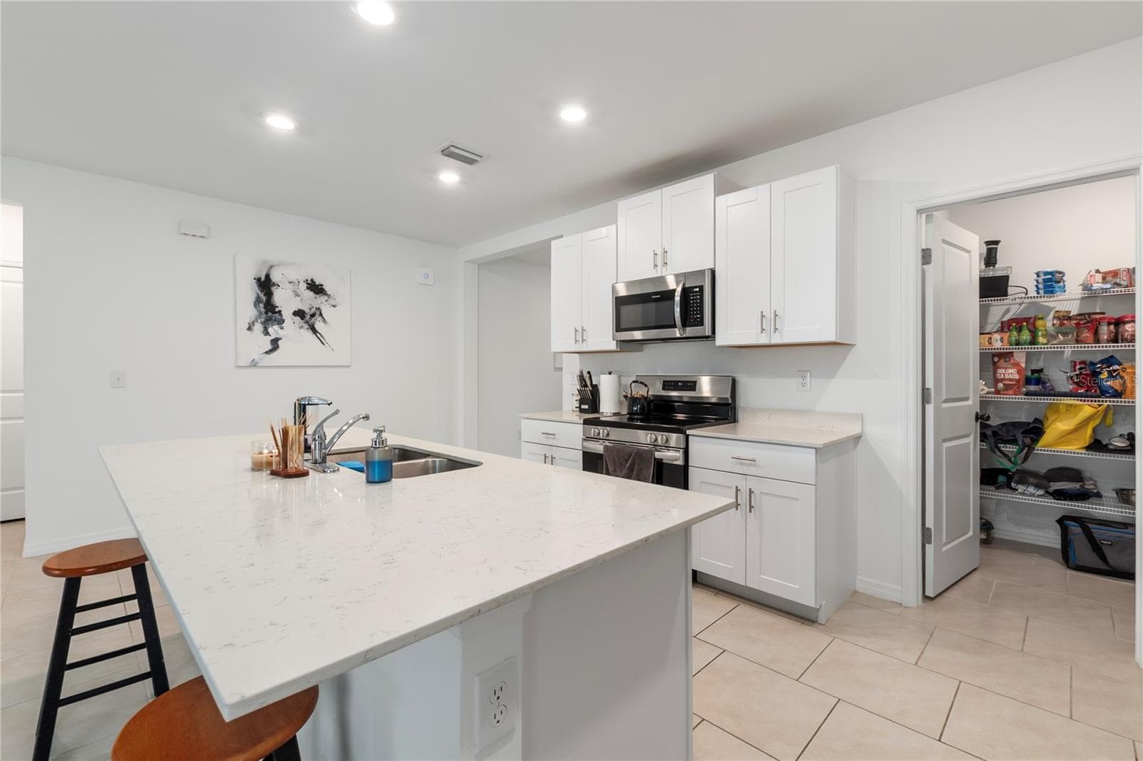 Gourmet kitchen with large center island, abundant cabinetry, and seamless flow into the living and dining areas. - 17177 MONTE ISOLA WAY, NORTH FORT MYERS