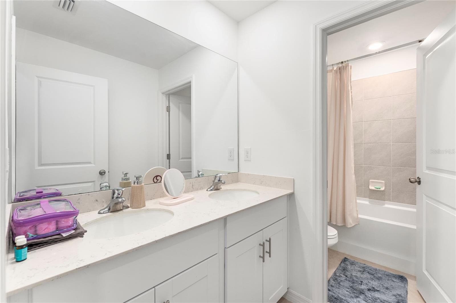 Modern guest bathroom with dual sinks and quartz countertops. - 17177 MONTE ISOLA WAY, NORTH FORT MYERS