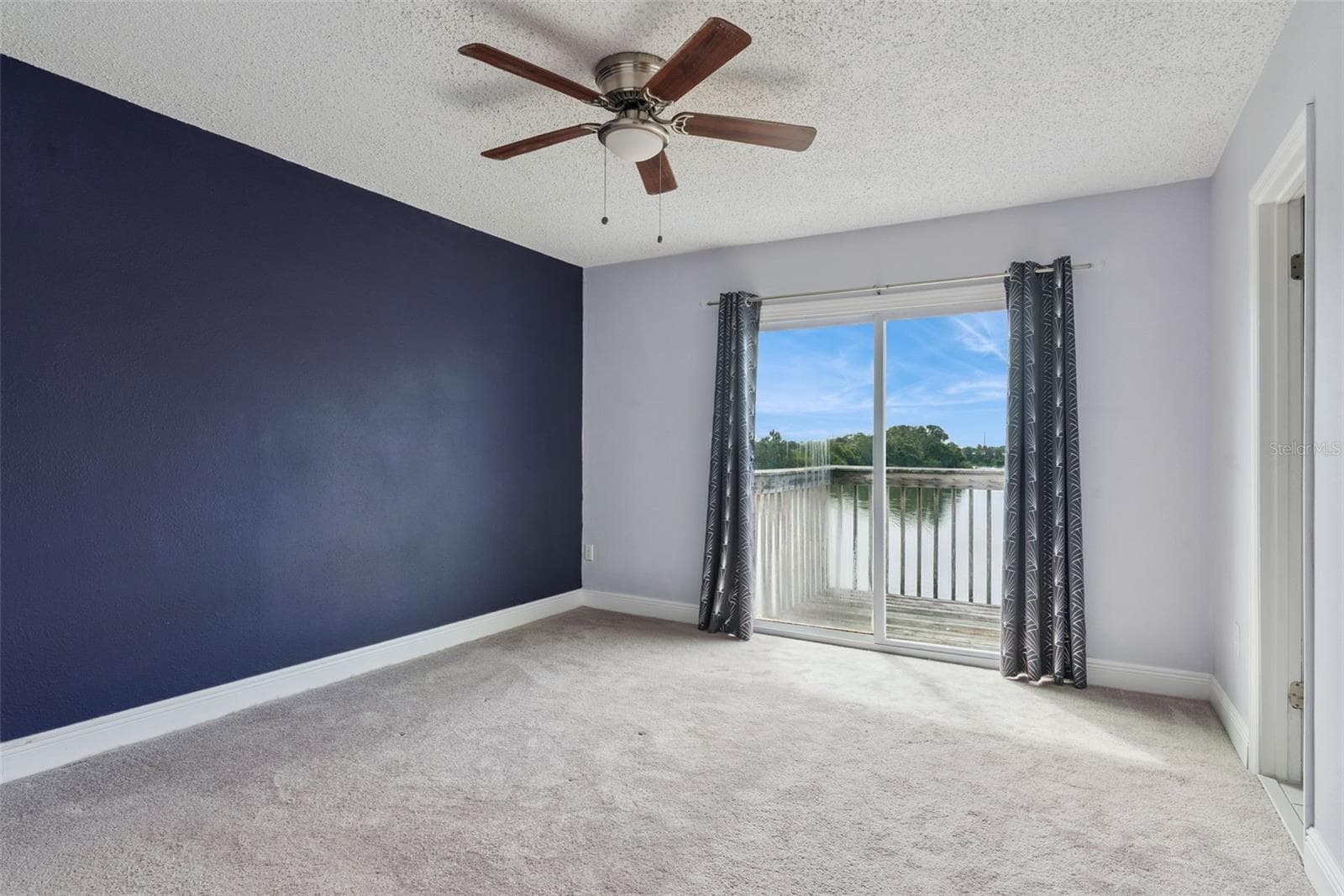 Primary Bedroom with view to the Balcony that overlooks the pond - 214 MAJORS LN #C, KISSIMMEE
