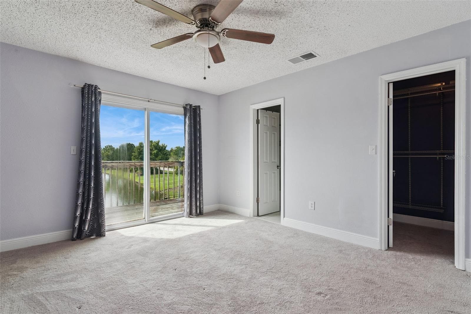 Primary Bedroom with view to the Balcony that overlooks the pond - 214 MAJORS LN #C, KISSIMMEE