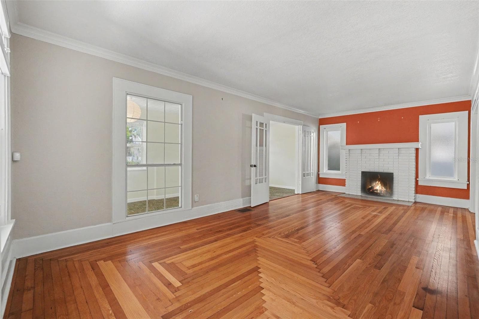 Sunlight, original wood floors, and a brick fireplace create a living room that feels warm, inviting, and unmistakably historic. - 857 21ST AVE N, ST PETERSBURG