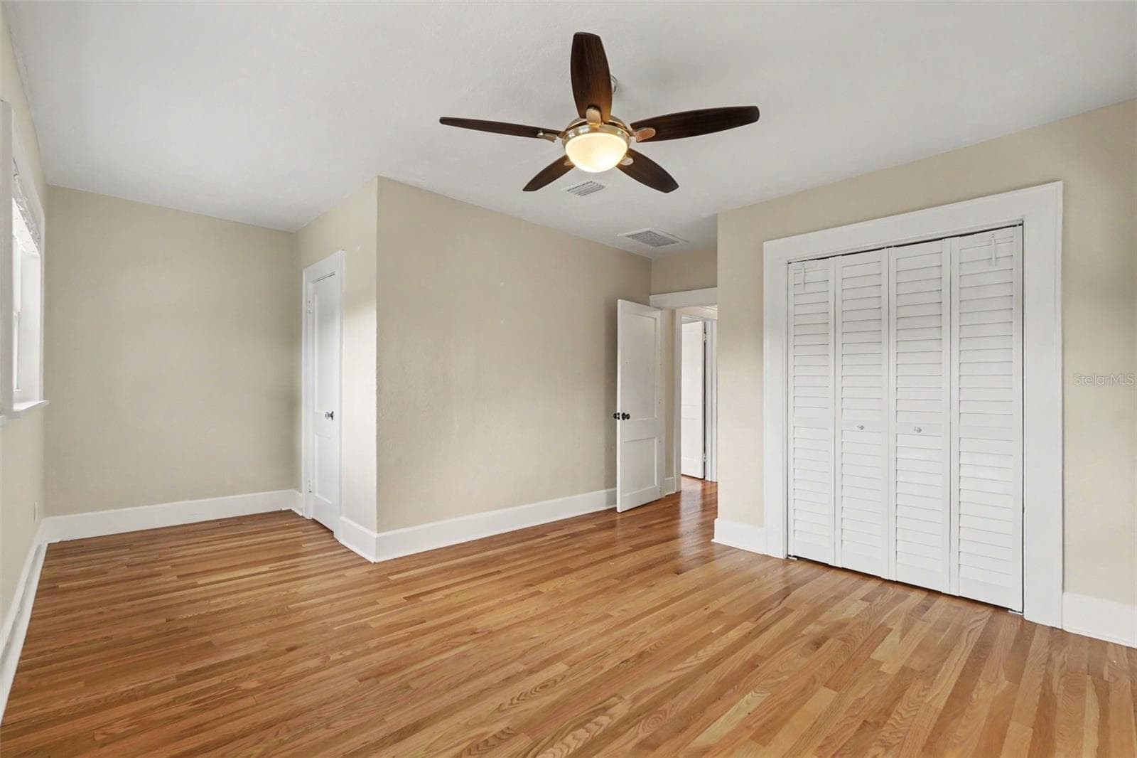 The fourth bedroom continues the home’s blend of character and comfort, with warm wood floors and generous closet space. - 857 21ST AVE N, ST PETERSBURG