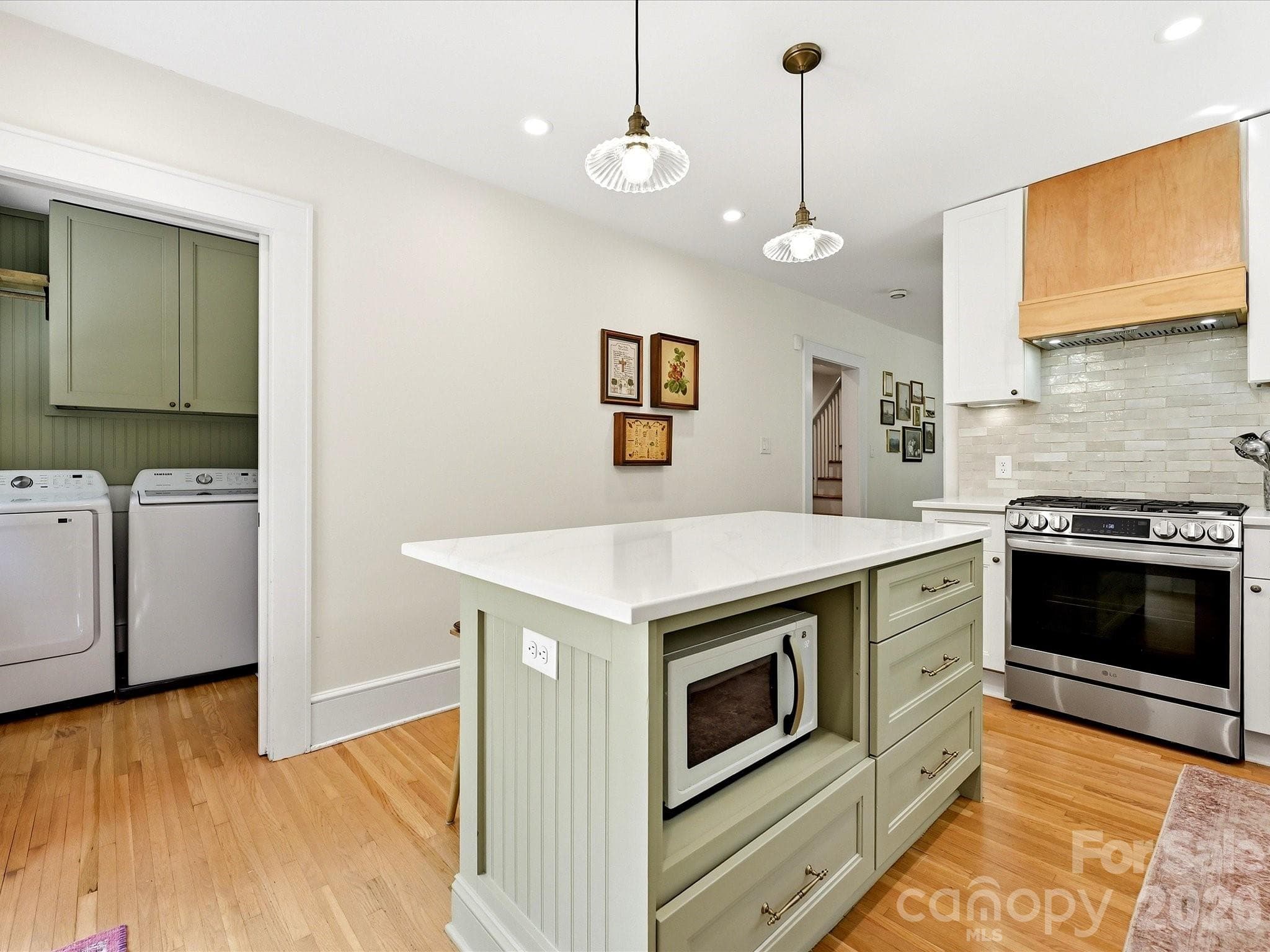 The thoughtfully designed kitchen offers a spacious island, ample cabinetry, and convenient access to the adjacent laundry room. - 3514 Kelly Road, Charlotte