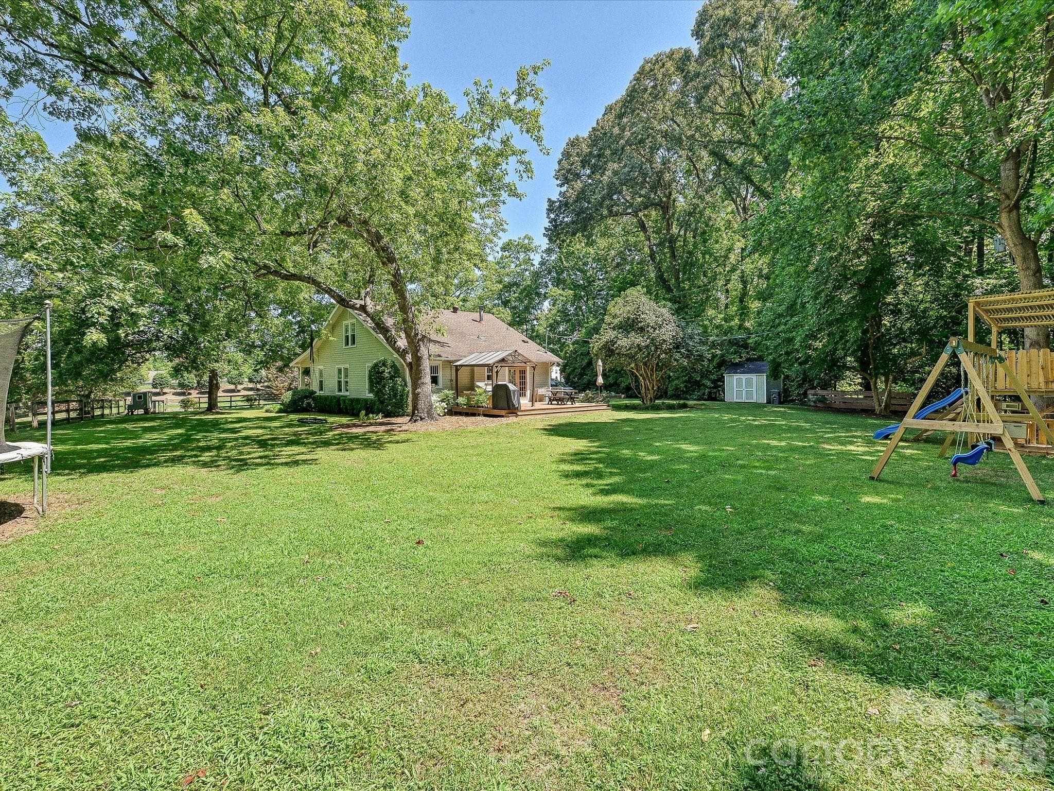 The large, level backyard offers endless opportunities for recreation, gardening, and outdoor enjoyment, surrounded by mature trees for added privacy. - 3514 Kelly Road, Charlotte