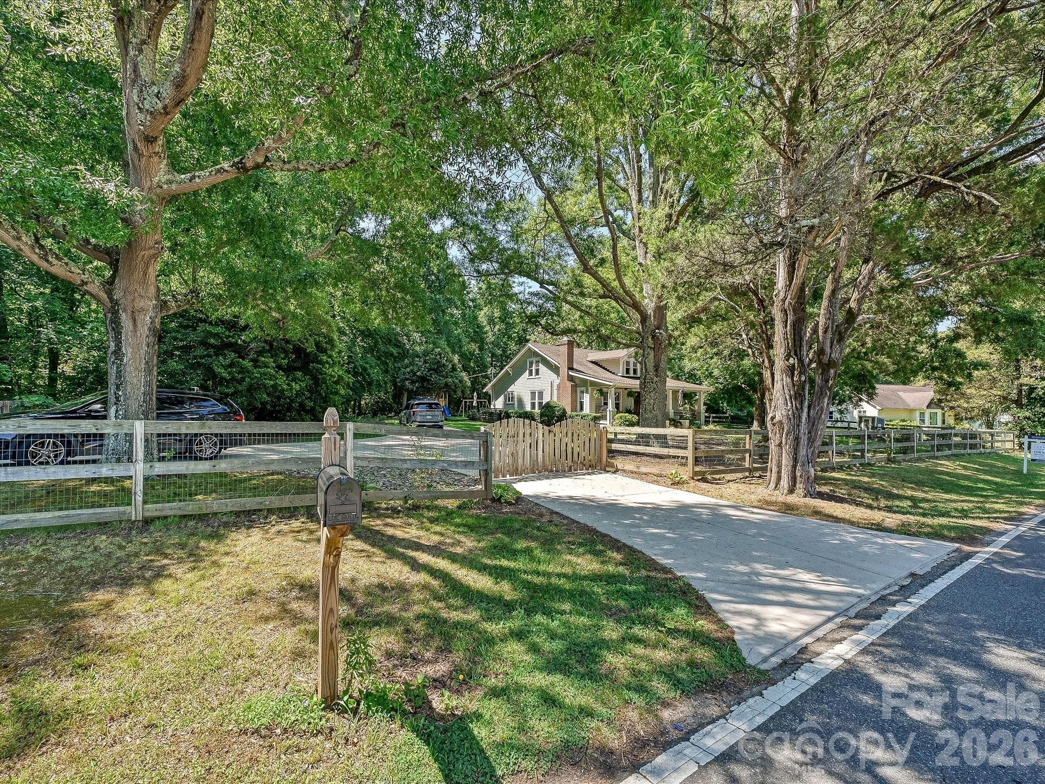 Nestled beneath mature shade trees on a picturesque homesite, this timeless home with fenced yard offers exceptional curb appeal and a peaceful country setting. - 3514 Kelly Road, Charlotte