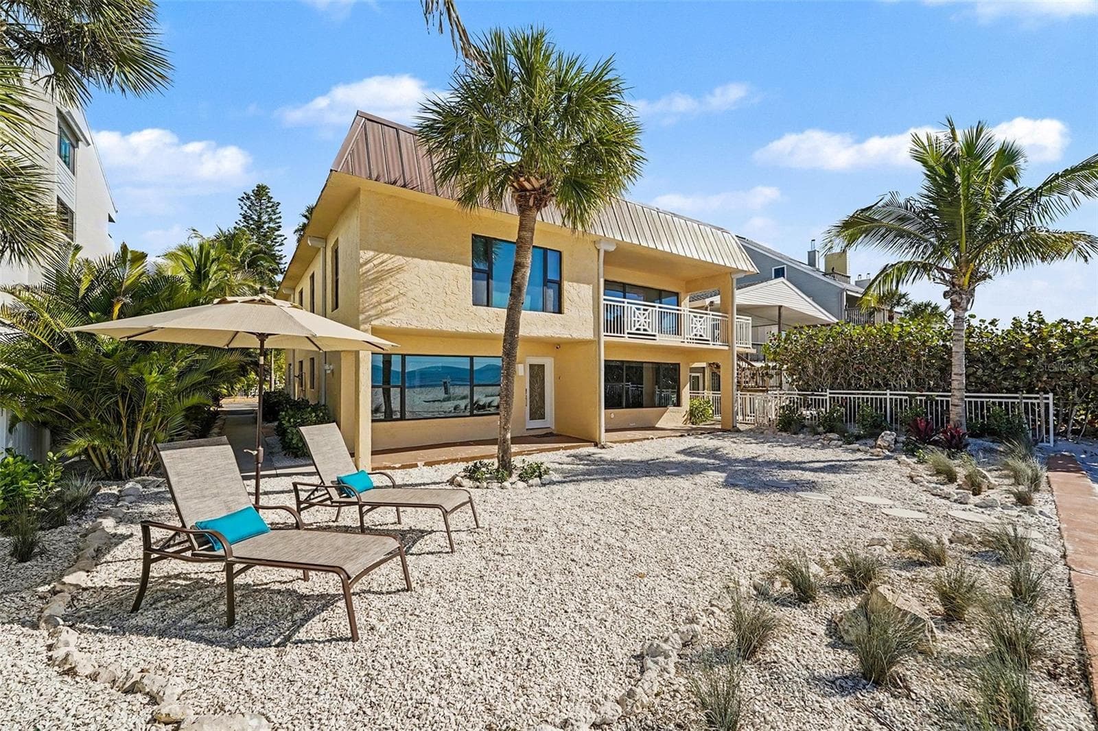 The property is configured as two full, condo-style living spaces with a total of five bedrooms and four baths and separate entrances. - 19936 GULF BLVD, INDIAN SHORES