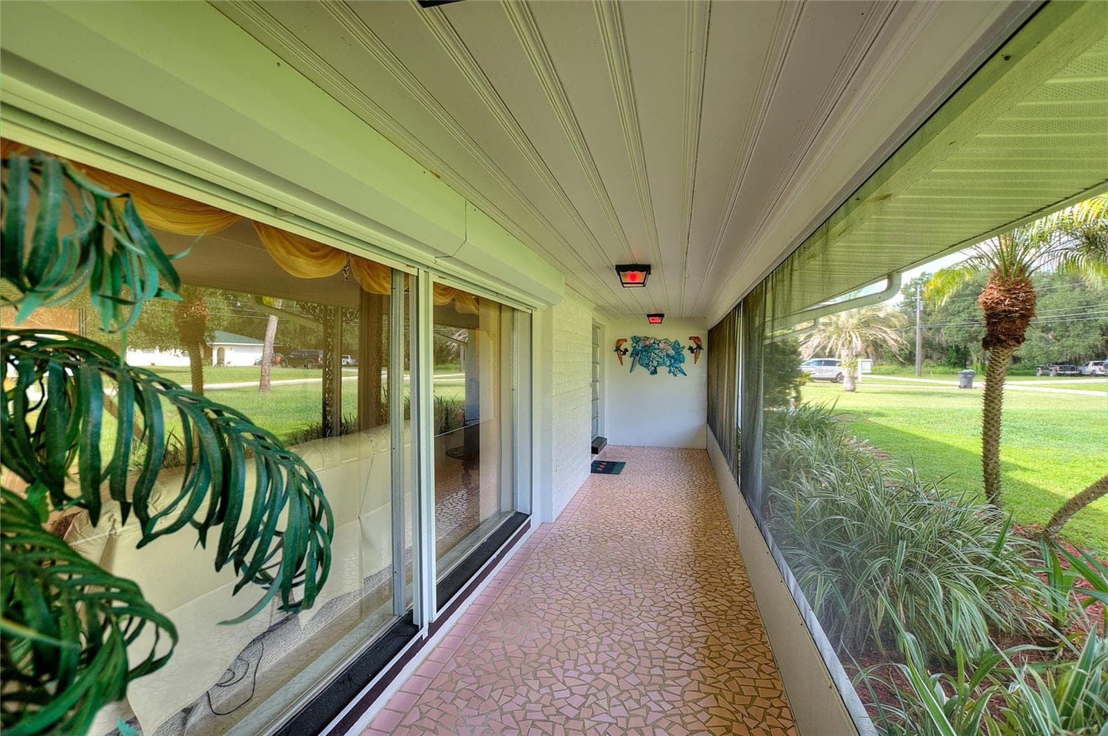 Beautiful porch with vintage broken tile. There are hurricane shutters on the big front windows. - 6197 AMARYLLIS DR, INDIAN LAKE ESTATES