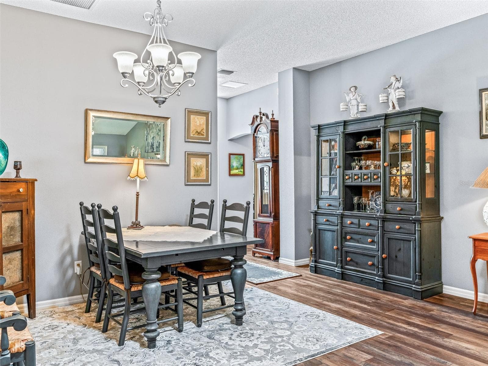 Comfortable dining space features an attractive chandelier, wood-look flooring, and room for a large table, china cabinet, or serving pieces. - 17946 SE 87TH MELROSE CT, THE VILLAGES
