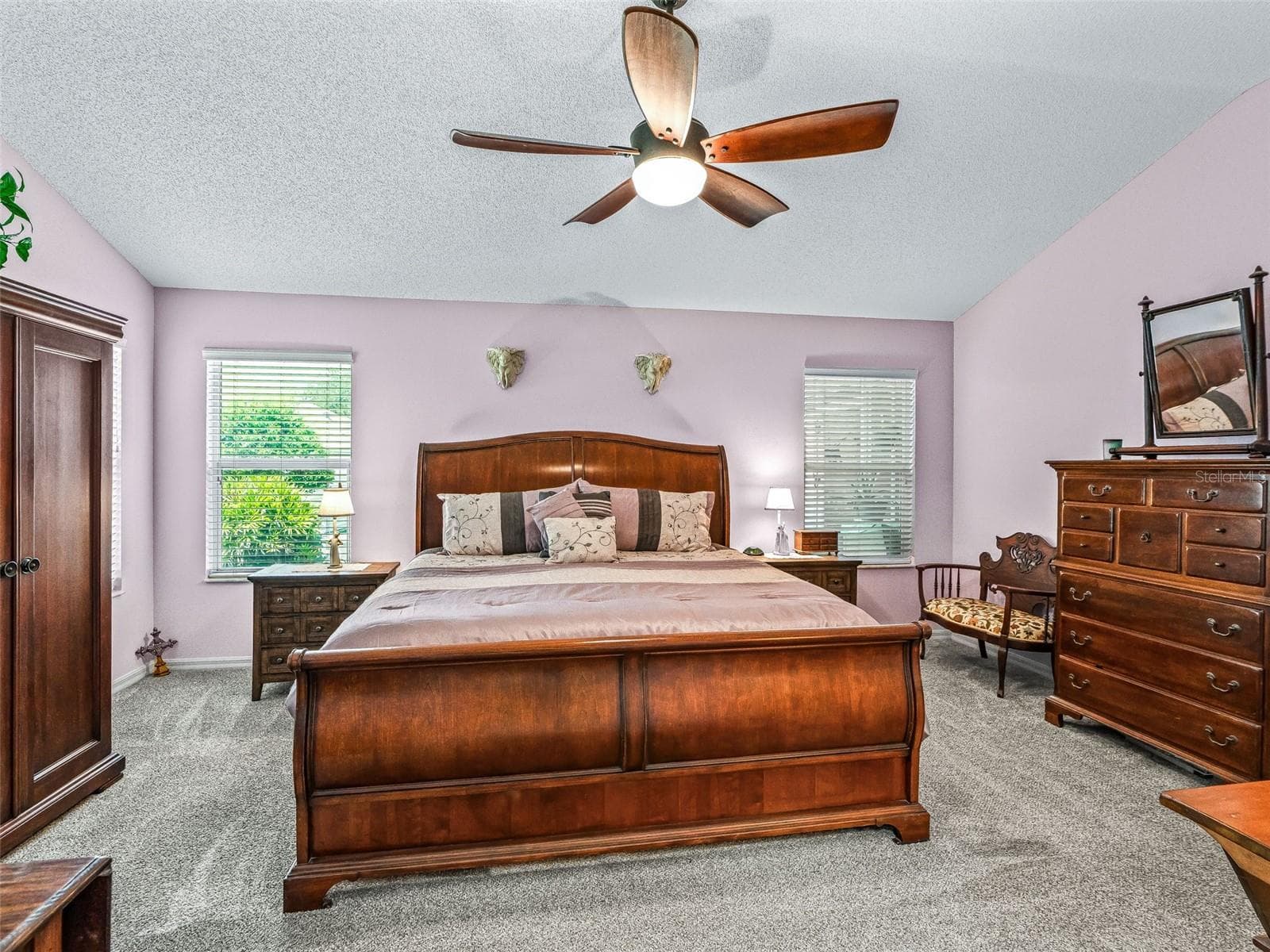 Natural light from multiple windows enhances the comfortable primary bedroom, which offers abundant floor space and a ceiling fan for added comfort. - 17946 SE 87TH MELROSE CT, THE VILLAGES