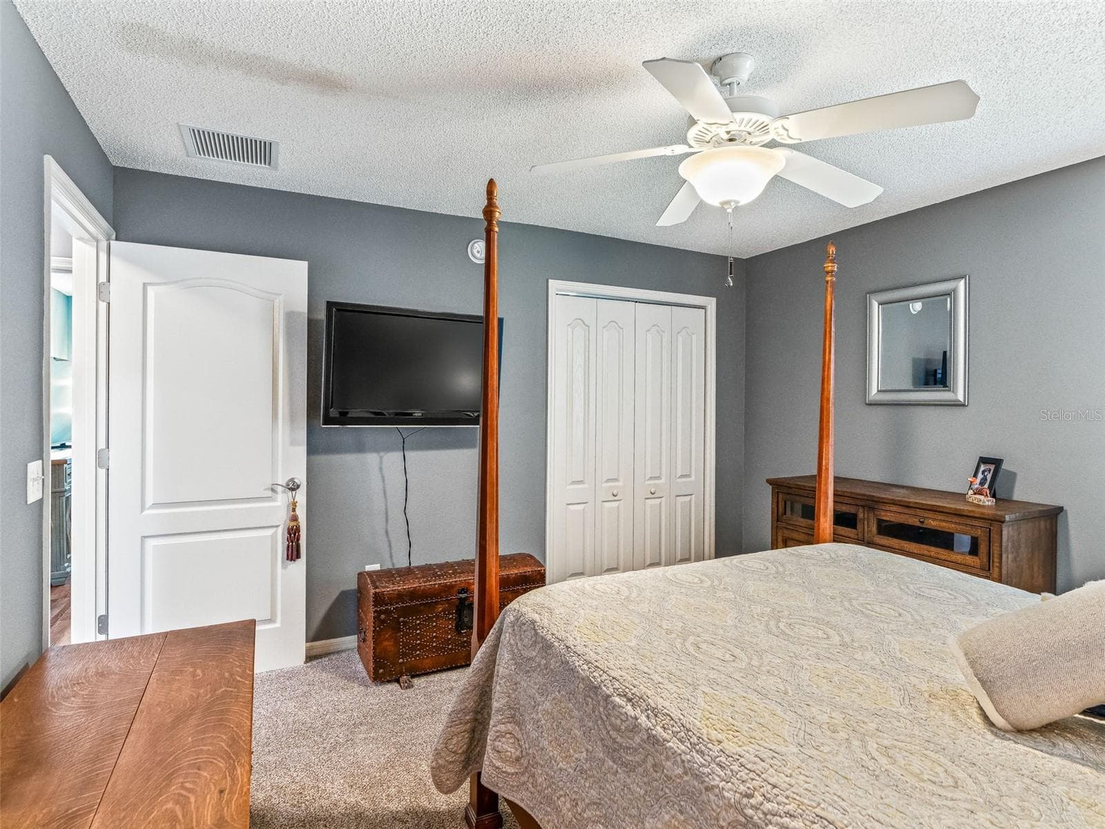 This welcoming bedroom offers a roomy layout, ceiling fan, closet storage, and easy access to the adjoining hallway. - 17946 SE 87TH MELROSE CT, THE VILLAGES