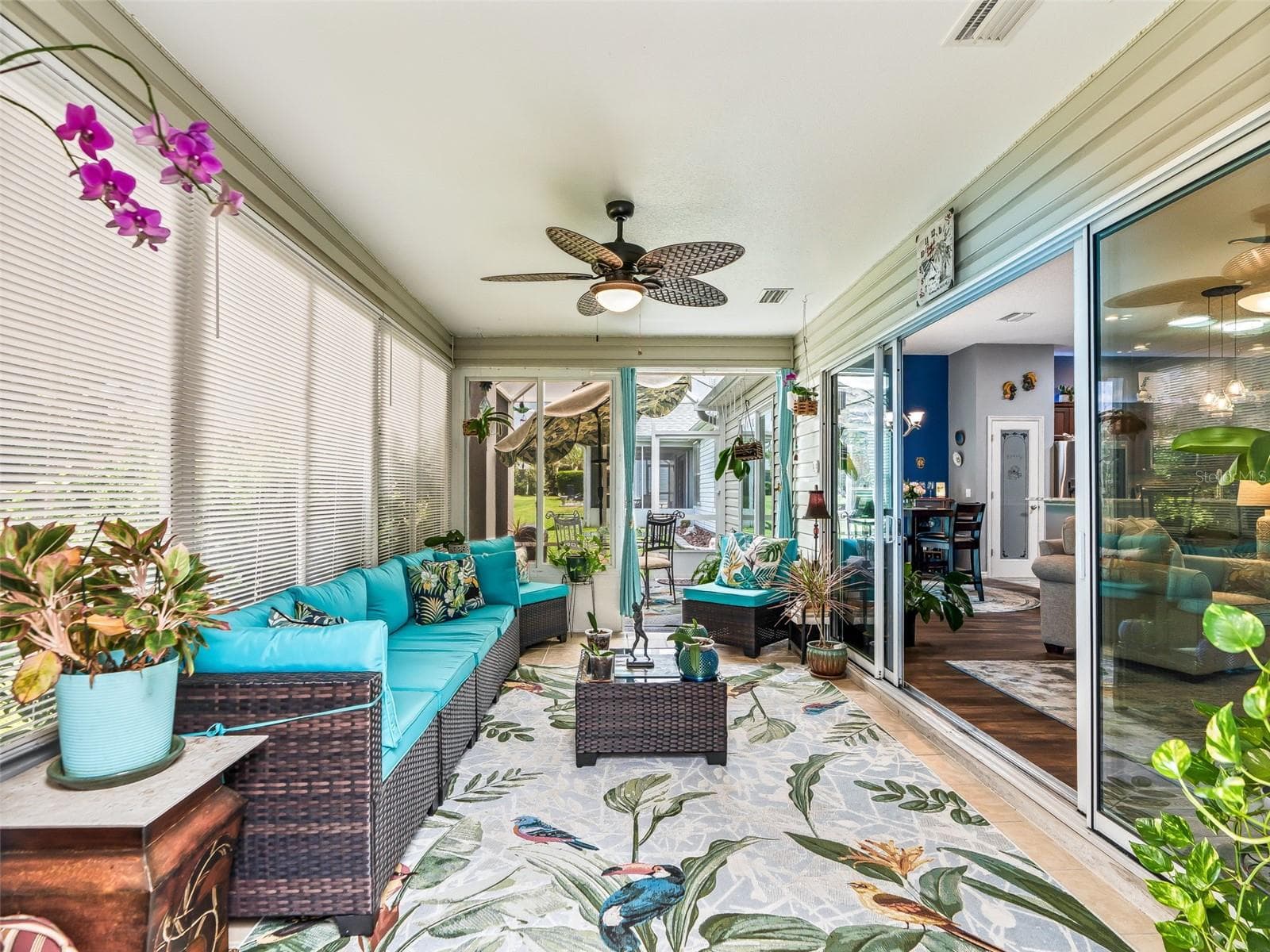 The enclosed lanai offers a long, versatile layout with multiple seating areas, sliding-glass access to the home, and a seamless connection to the outdoor spa and eating areas. - 17946 SE 87TH MELROSE CT, THE VILLAGES