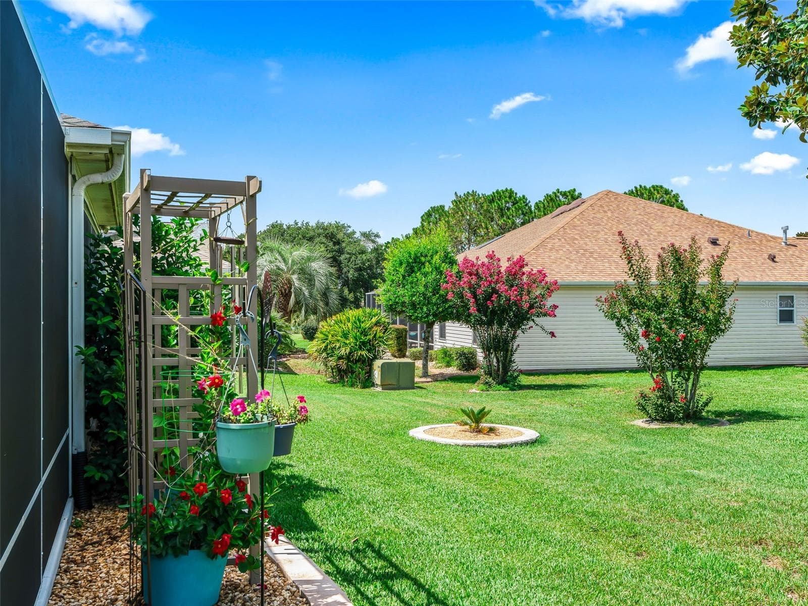 The open backyard offers generous green space, established landscaping, and ample room to enjoy Florida’s year-round sunshine. - 17946 SE 87TH MELROSE CT, THE VILLAGES