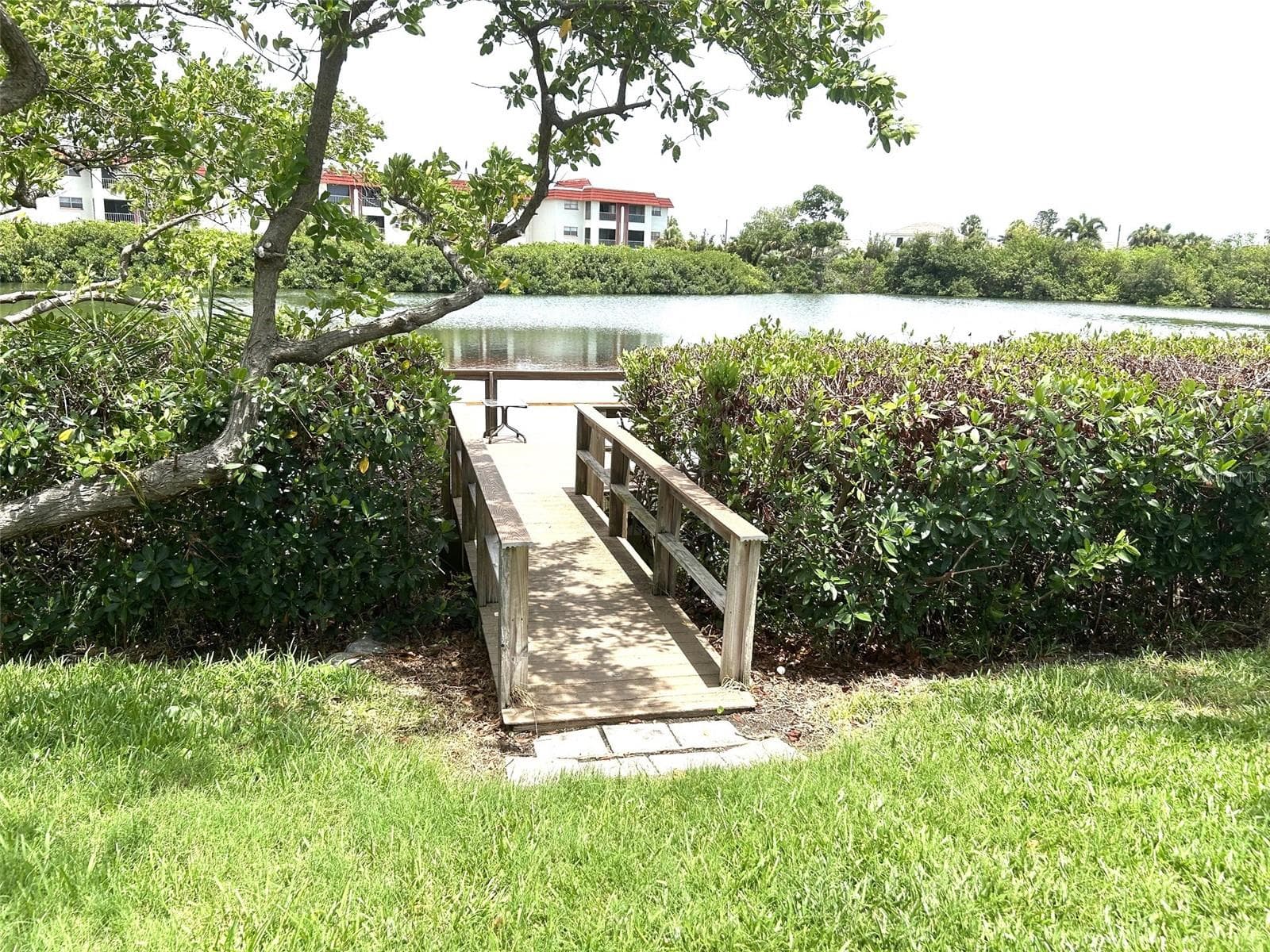 Walkway to deck by the pond adjacent to clubhouse - 4520 OVERLOOK DR NE #132, ST PETERSBURG