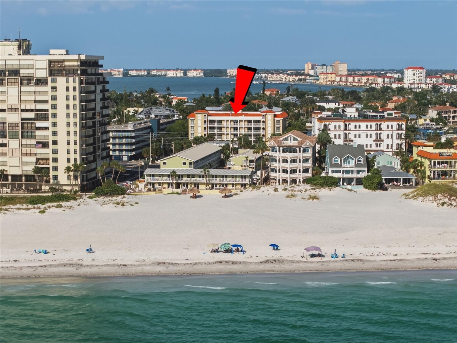 This photo highlights the building's prime location and its immediate proximity to the beach. - 3805 GULF BLVD #203, ST PETE BEACH