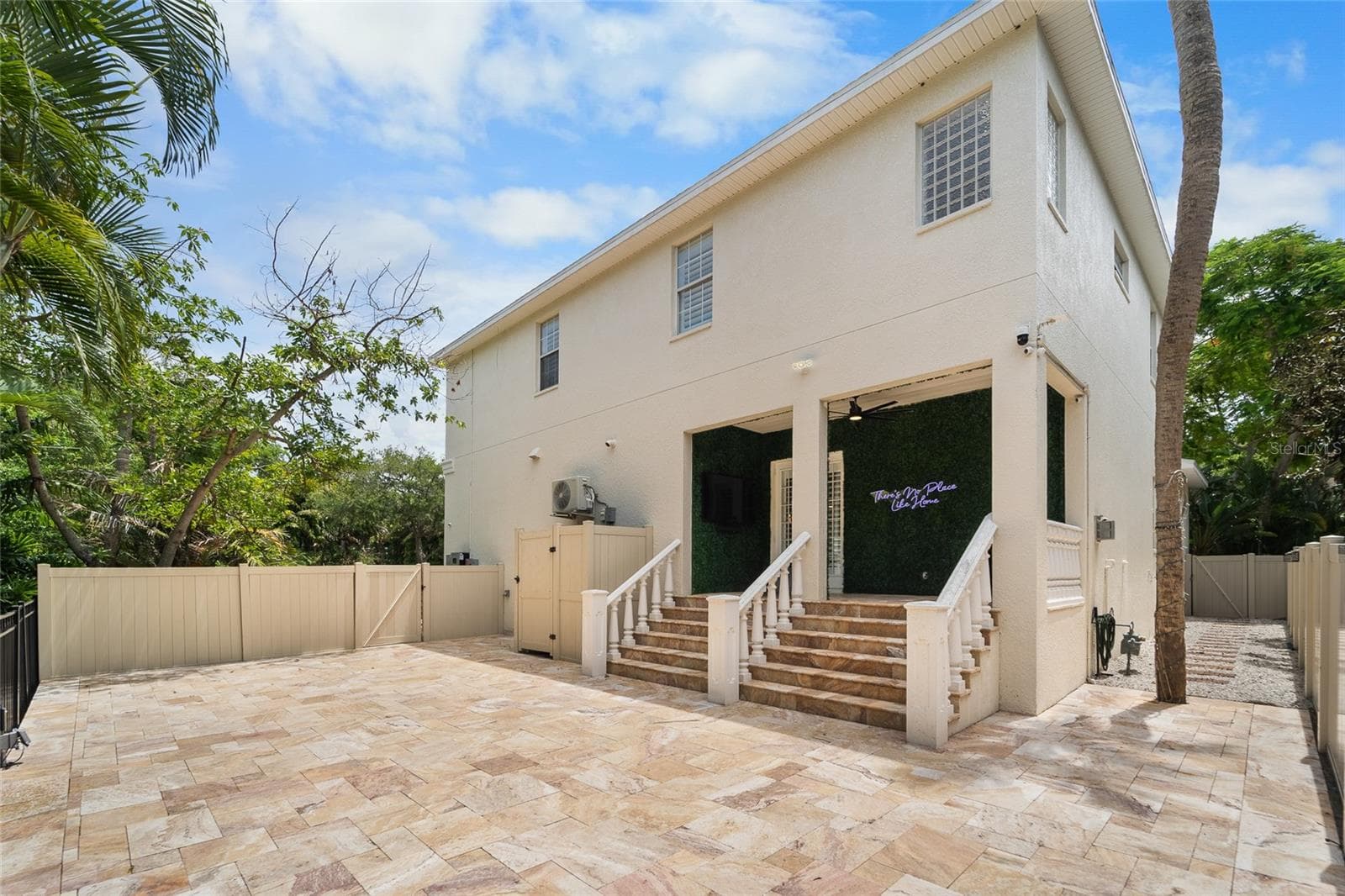 Low-maintenance backyard featuring professional hardscaping with full paver coverage and no grass. - 4802 W BEACHWAY DR, TAMPA