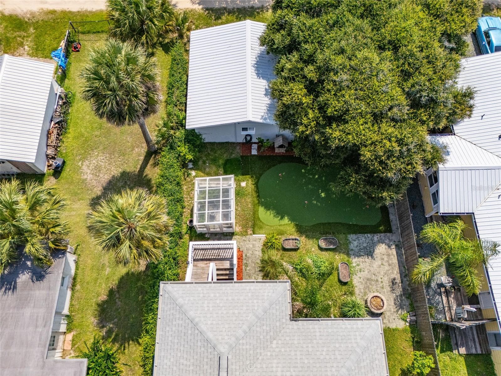 View of single family home, greenhouse, putting green, paver area, fire pit and apartment/in-law suite - 904 S DAYTONA AVE, FLAGLER BEACH