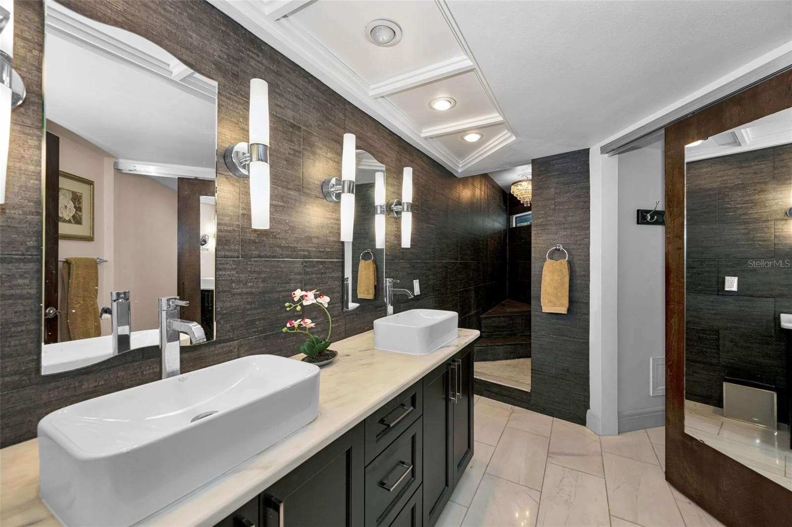 The master bath with double vanities, custom lighting and mirrors, huge walk in shower lit by a gorgeous chandelier! There is a linen closet and private toilet area as well. - 10497 LONGWOOD DR, SEMINOLE