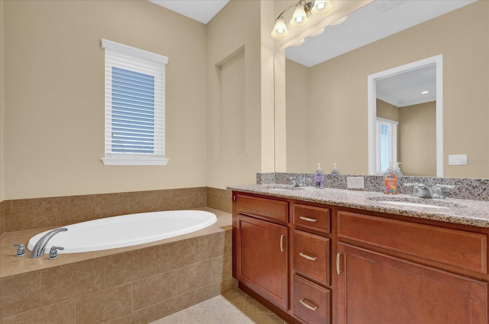 Spa-inspired primary bath featuring a relaxing garden soaking tub. - 9219 LAUREATE BLVD, ORLANDO