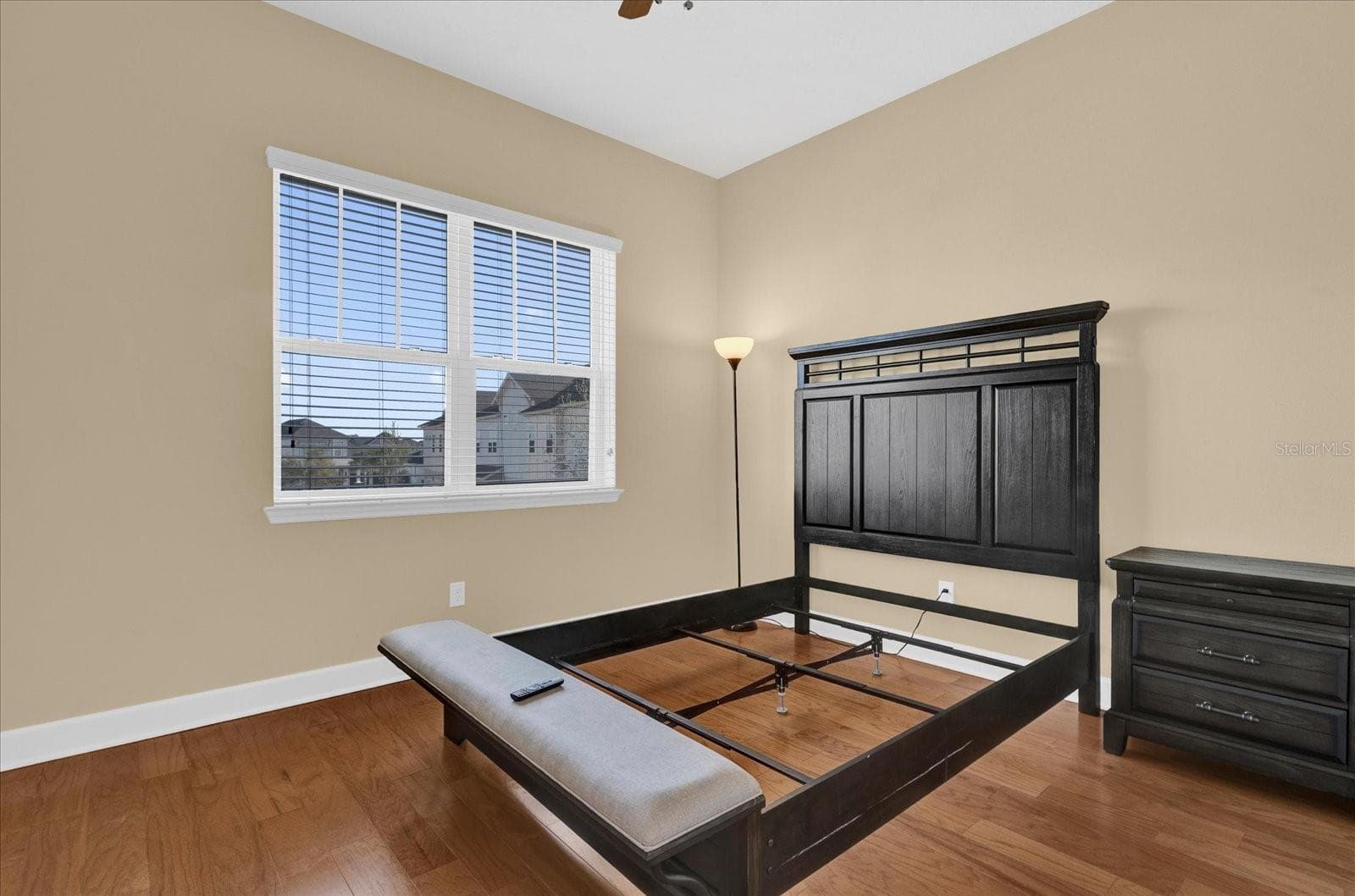 Comfortable third bedroom with rich hardwood flooring and a bright window view. - 9219 LAUREATE BLVD, ORLANDO