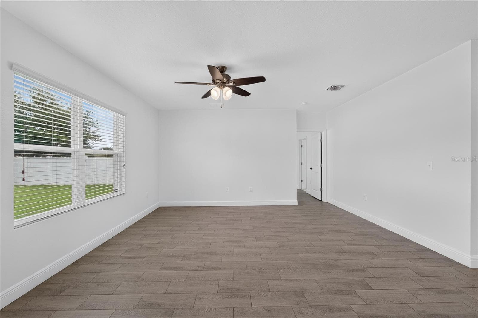 Living Room with large windows and hall to Primary Bedroom and Bath - 9637 TRONCAIS CIR, THONOTOSASSA