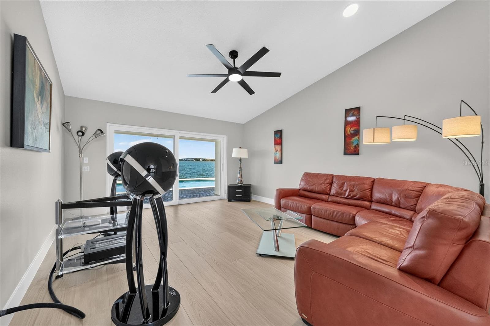 Elegant formal living room featuring sliding glass doors that frame serene water views and fill the space with natural light. - 2936 68TH AVE S, ST PETERSBURG