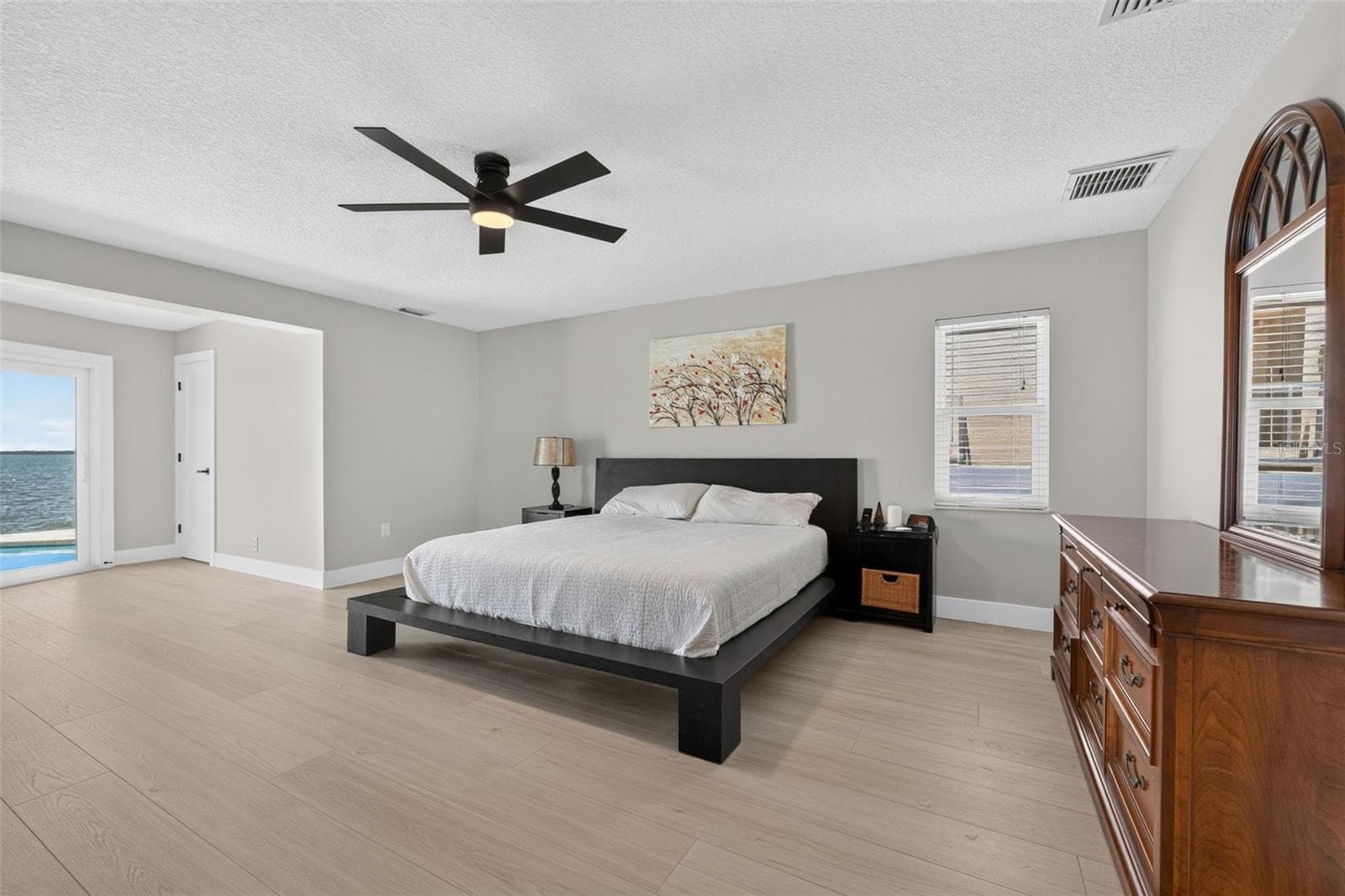Spacious primary bedroom with new luxury vinyl plank flooring, offering plenty of room for all your furniture and personal touches. - 2936 68TH AVE S, ST PETERSBURG