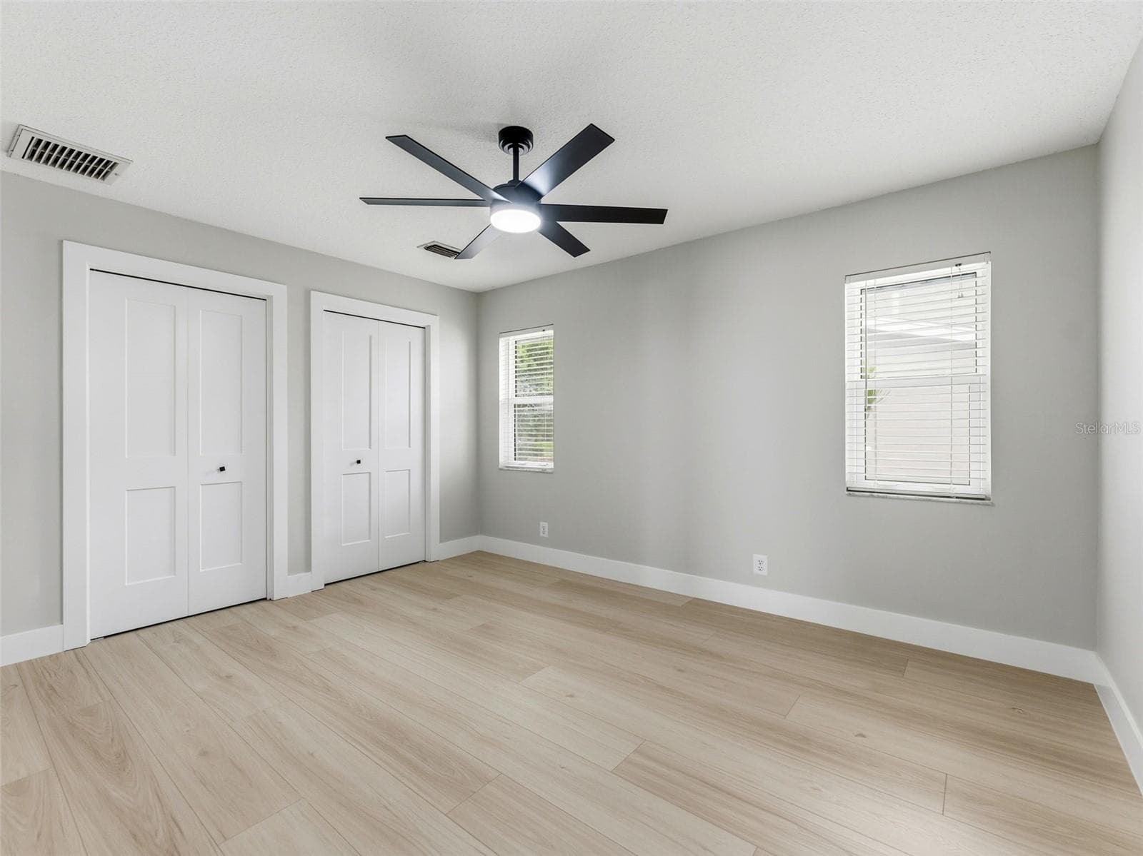 Bedroom 3 with luxury vinyl plank floors and a custom built-in closet, offering plenty of storage and comfort. - 2936 68TH AVE S, ST PETERSBURG
