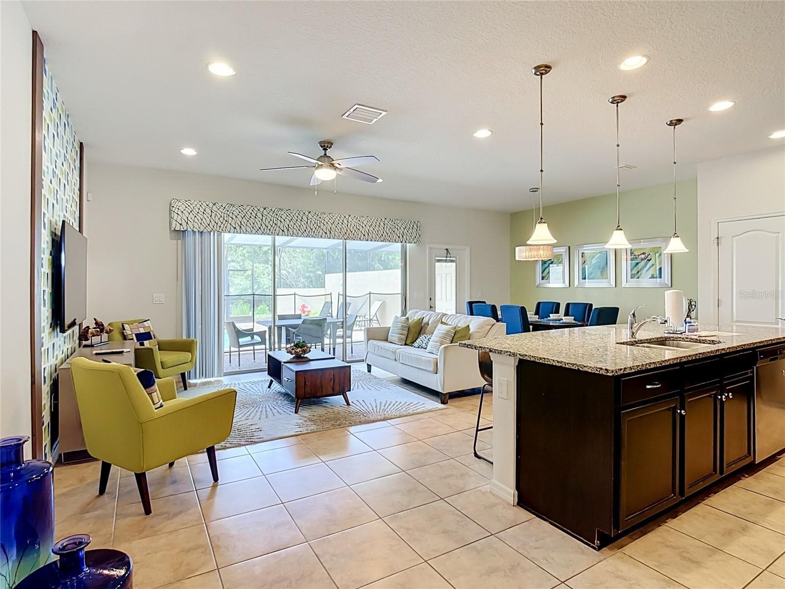 Bright open-concept living area with pond views - 8899 GENEVE CT, KISSIMMEE