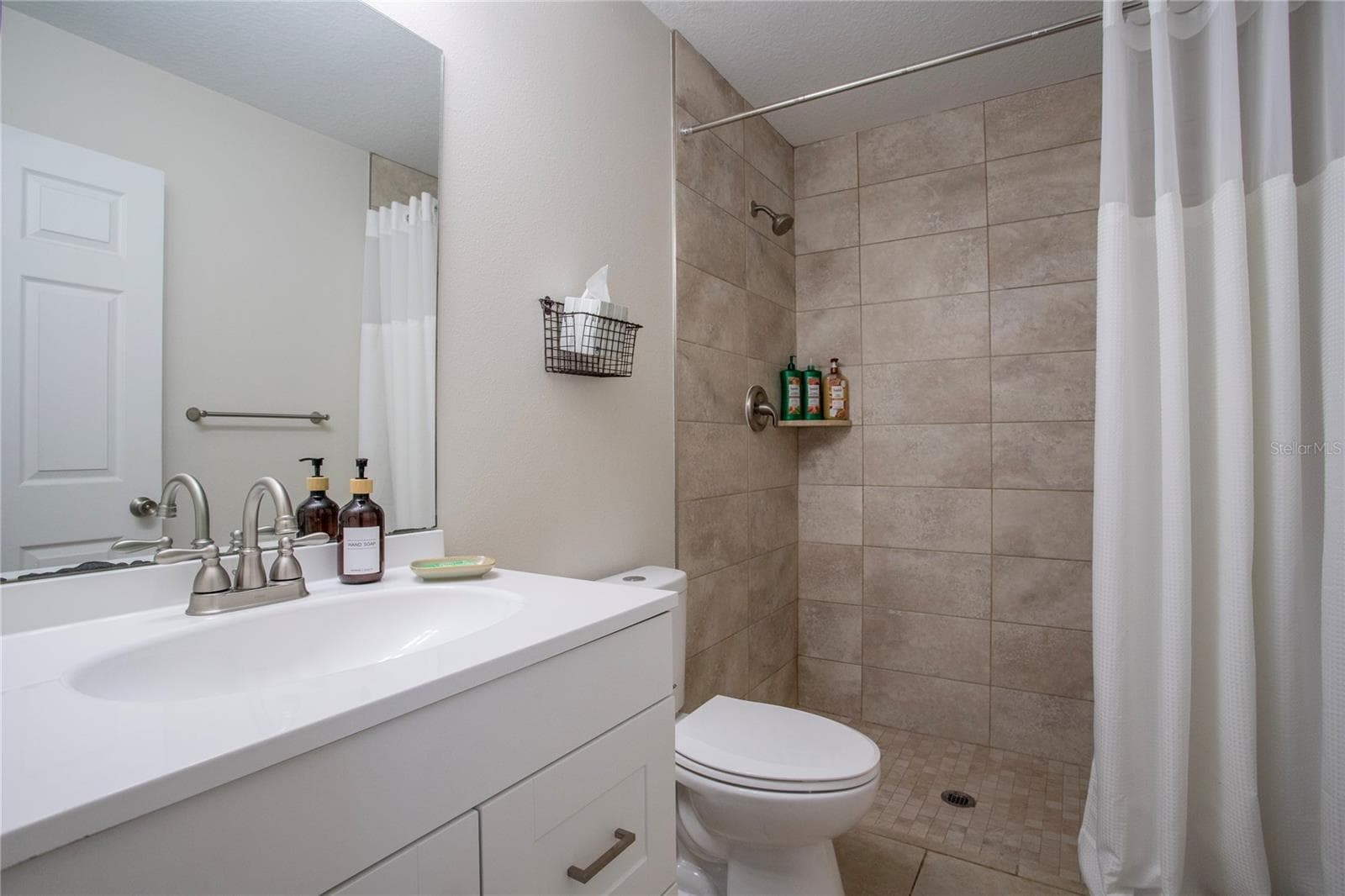 Primary bathroom with a shower and single vanity - 1202 S DEWEY ST, EUSTIS