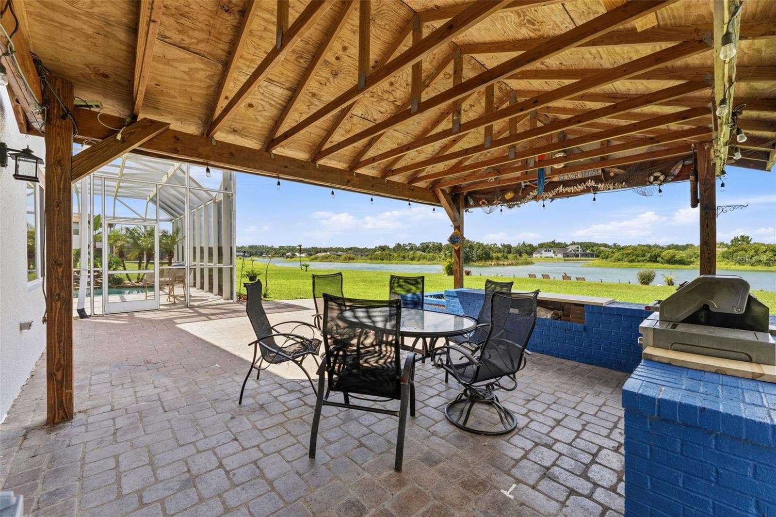 Backyard BBQ Under A Covered Patio Overlooking Scenic Lake Views - 24355 HIDEOUT TRL, LAND O LAKES