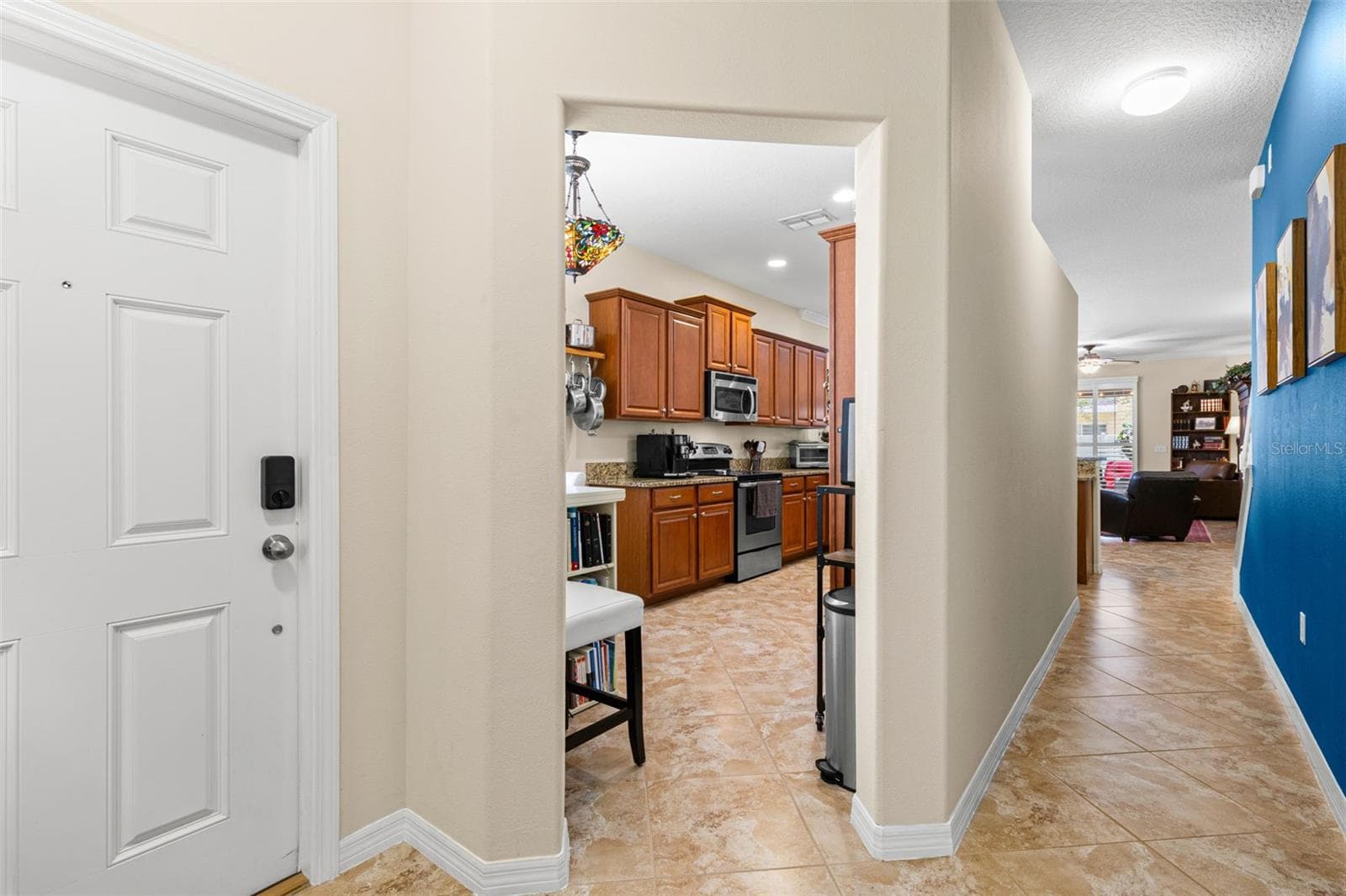 The front entry opens to diagonal tile flooring, a direct view into the kitchen and an easy sightline toward the living area beyond. - 9524 TRUMPET VINE LOOP, NEW PORT RICHEY