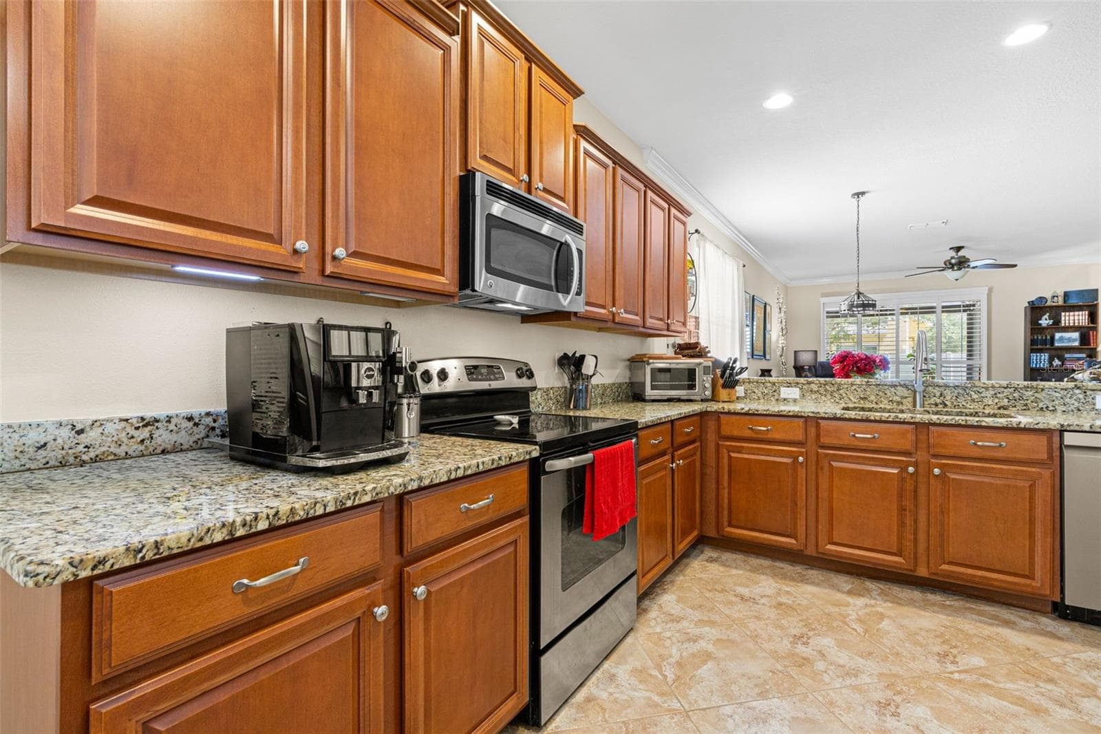 Solid wood cabinetry, granite counters and recessed lighting give the kitchen a warm, polished look with plenty of workspace and storage. - 9524 TRUMPET VINE LOOP, NEW PORT RICHEY