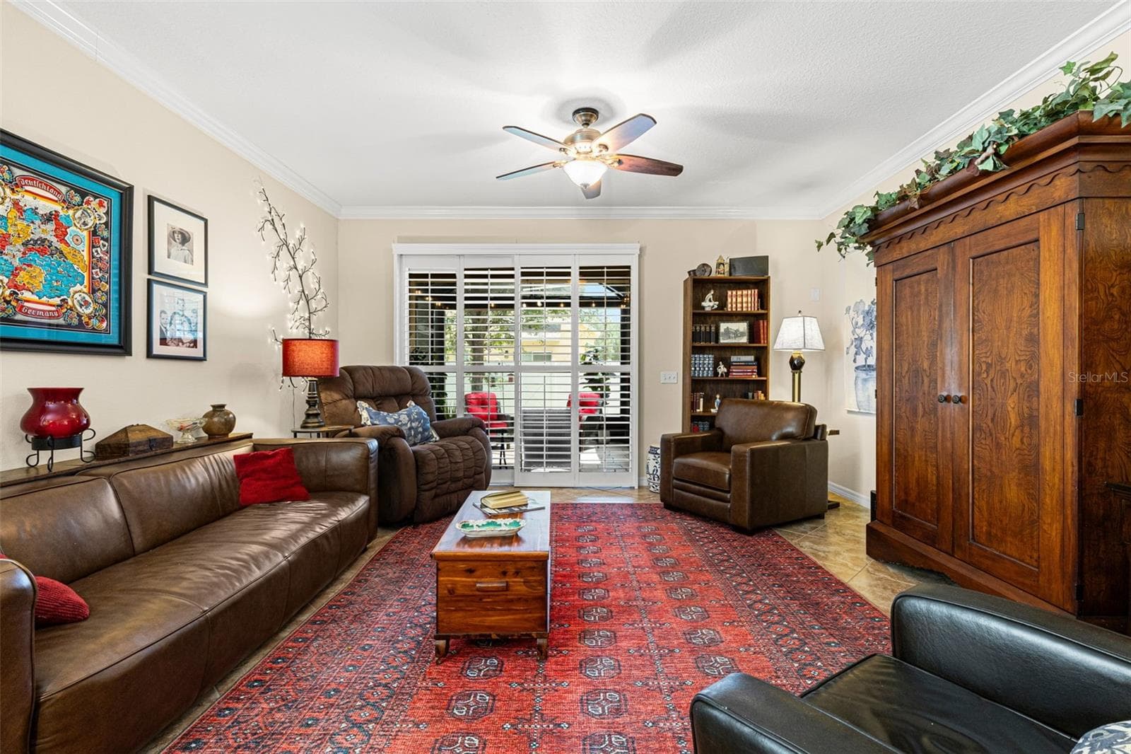 The living room has room for full-size furnishings, with crown molding, a ceiling fan and plantation shutters across the doors to the screened lanai. - 9524 TRUMPET VINE LOOP, NEW PORT RICHEY
