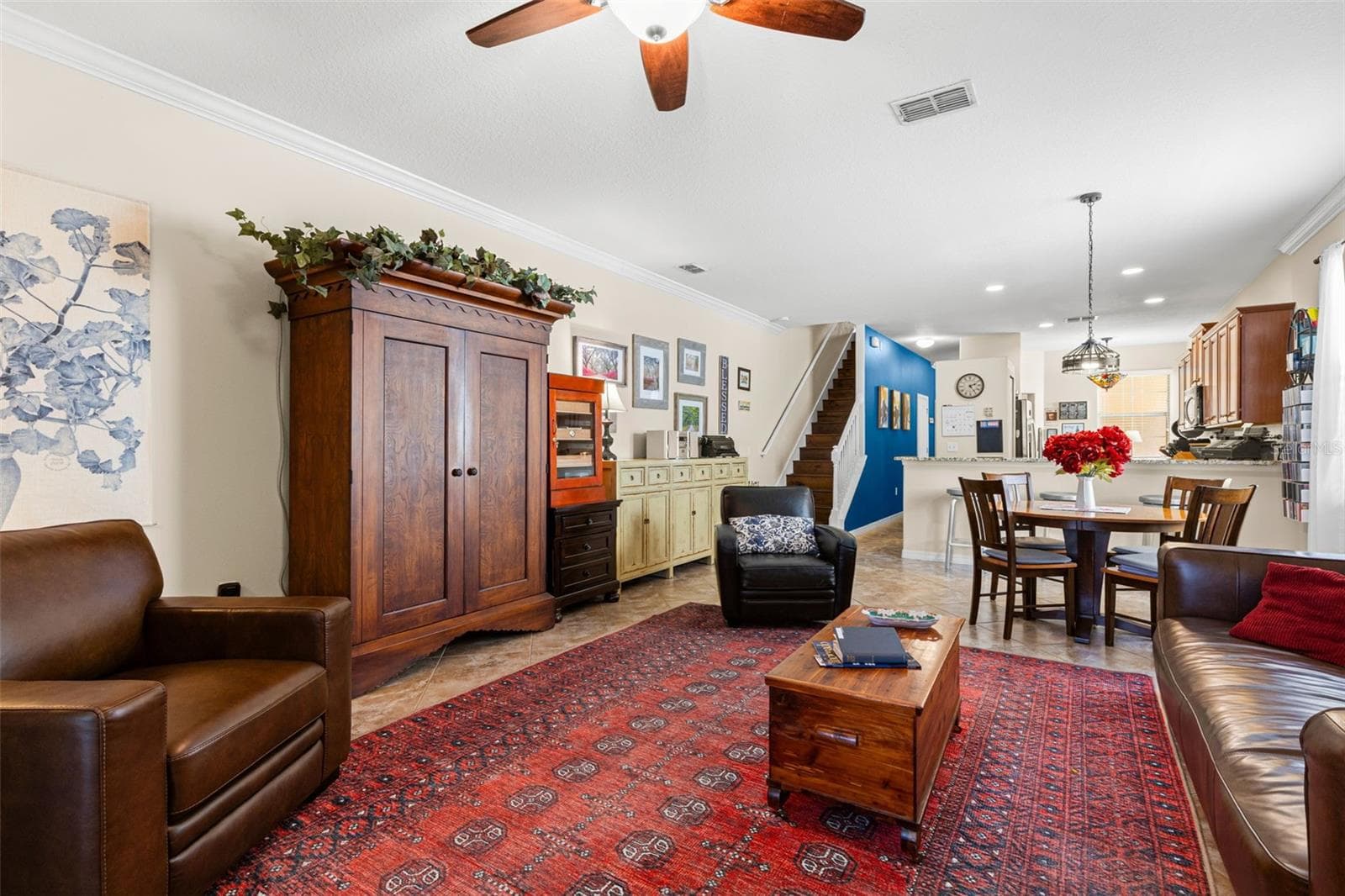 Another view of the living room shows its generous scale and easy connection to the dining area and kitchen, with crown molding continuing throughout the first floor. - 9524 TRUMPET VINE LOOP, NEW PORT RICHEY