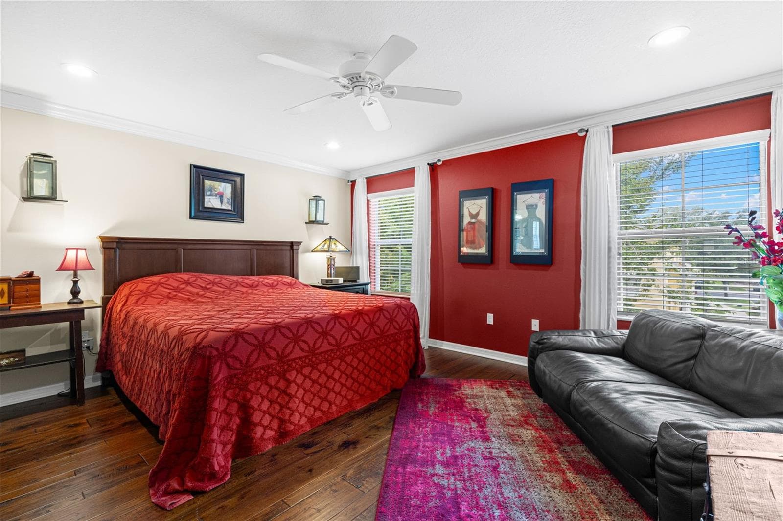 The spacious primary bedroom offers hardwood flooring, a ceiling fan and room for a sitting area, with three windows bringing in plenty of natural light. - 9524 TRUMPET VINE LOOP, NEW PORT RICHEY
