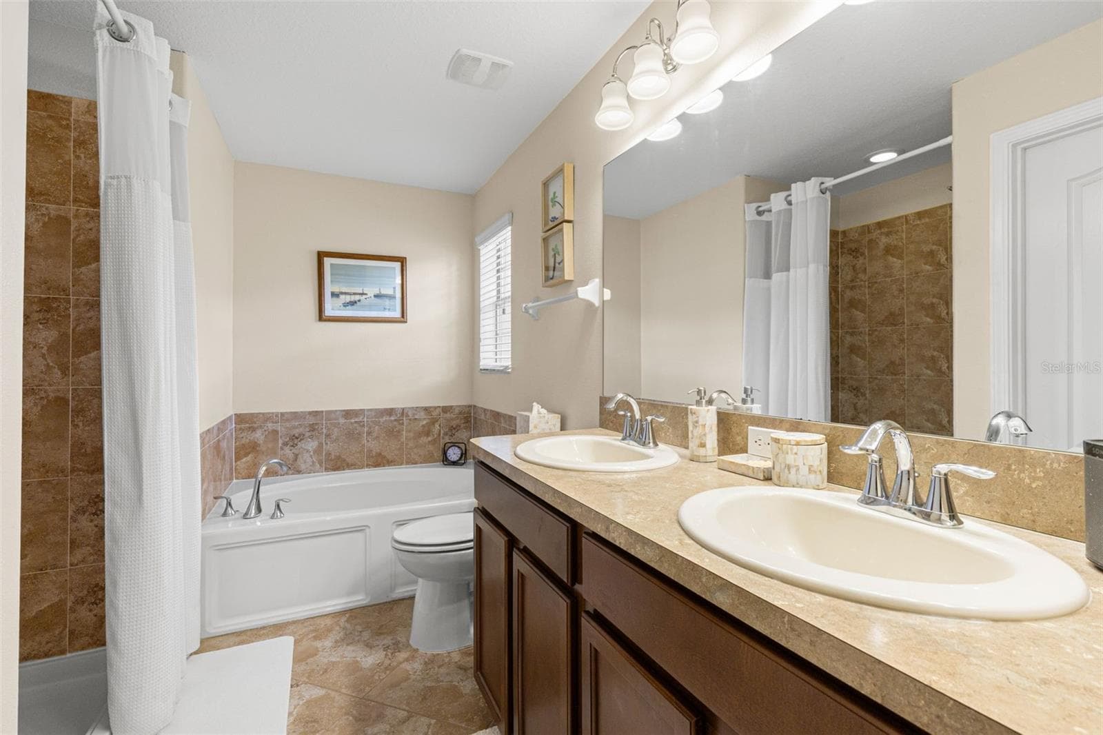 The en suite bath includes a double vanity, soaking tub and separate shower, with a window bringing in natural light. - 9524 TRUMPET VINE LOOP, NEW PORT RICHEY