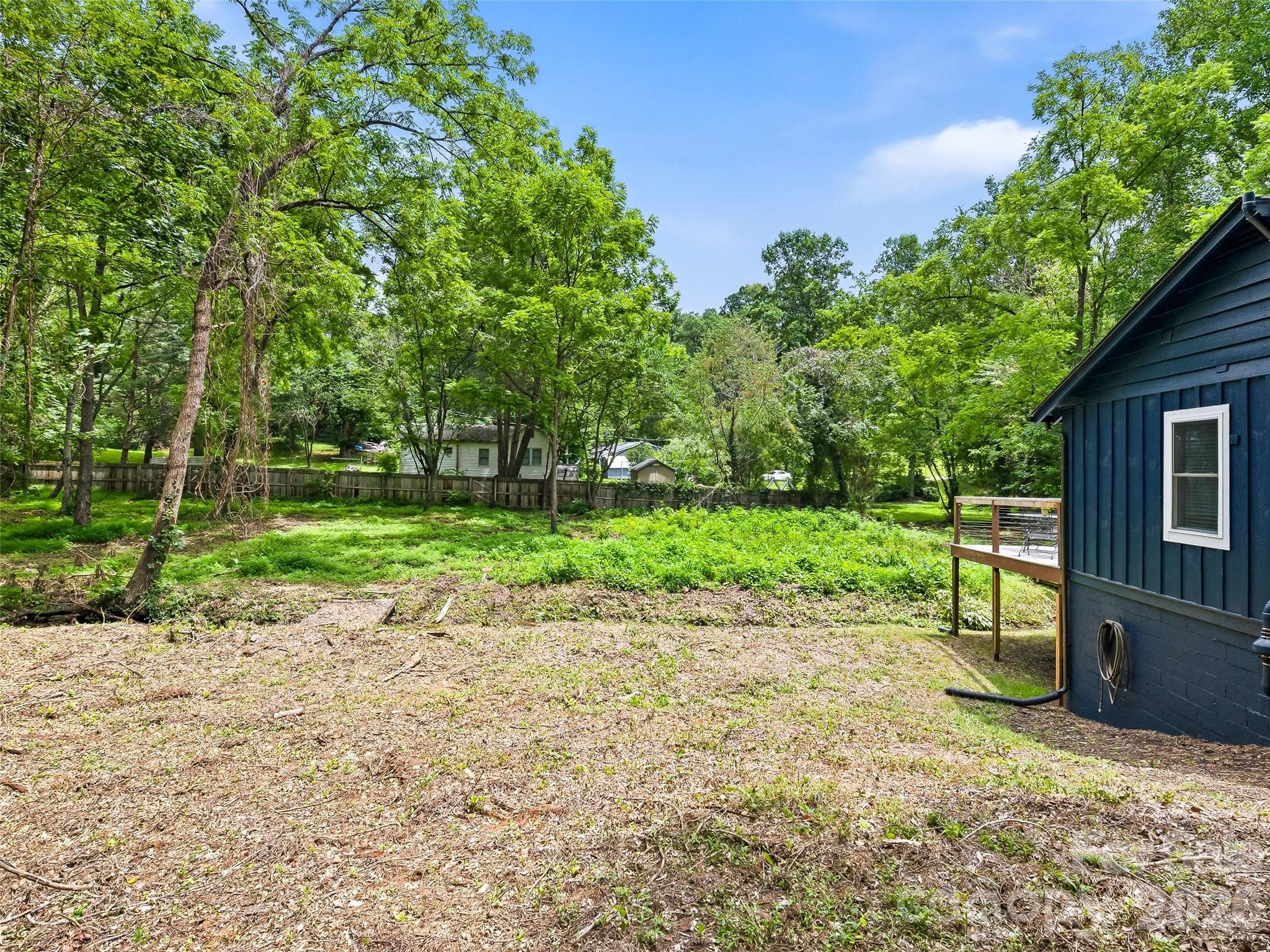 Side lawn looking across creek to expansive backyard. - 468 Governors View Road, Asheville