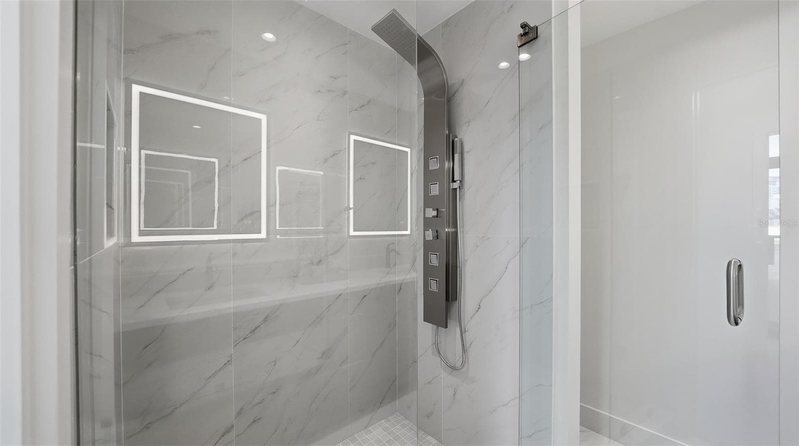 Primary Suite bathroom features bright all white finishes with walk in 'power' shower with body jets and handheld shower AND Euro glass shower enclosure. - 430 KUMQUAT CT #202, SARASOTA