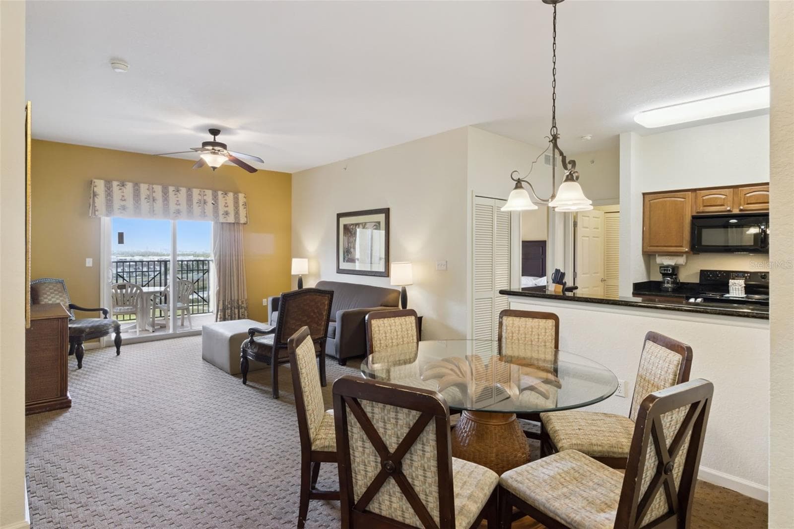 Living and Dining Area | An open layout connects the dining space, living room, kitchen, and balcony. - 8101 RESORT VILLAGE DR #31110, ORLANDO