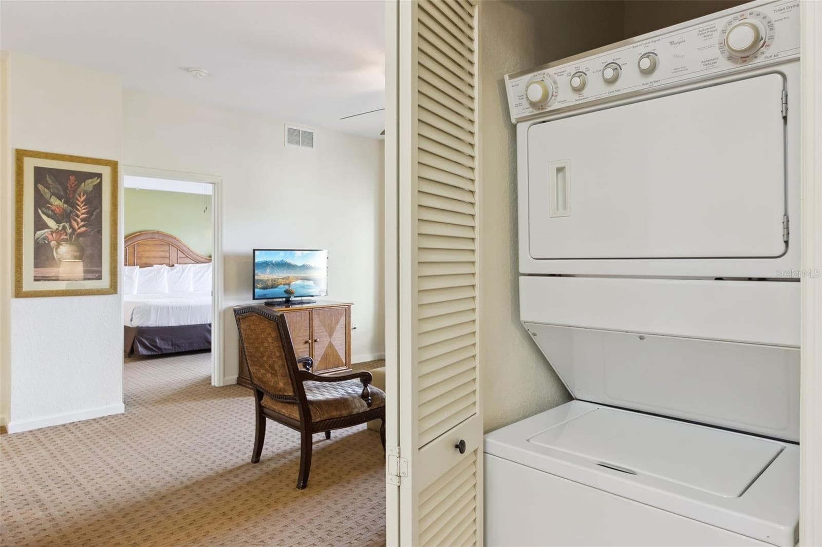 In-Unit Laundry | A concealed stacked washer and dryer add everyday convenience without taking up valuable living space. - 8101 RESORT VILLAGE DR #31110, ORLANDO