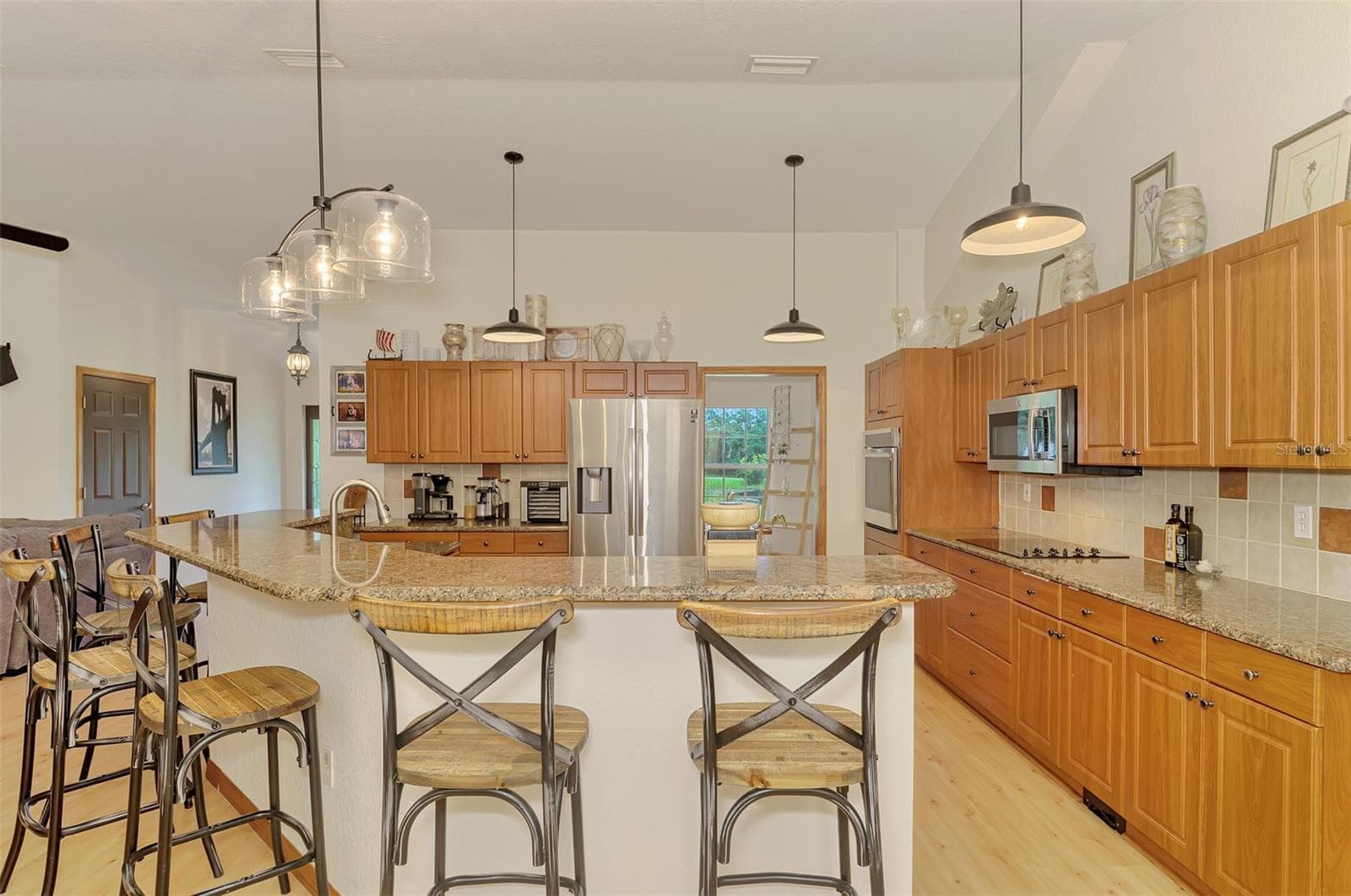 Granite counters and tile backsplash and upgraded lighting in the kitchen - 4610 403RD ST E, MYAKKA CITY