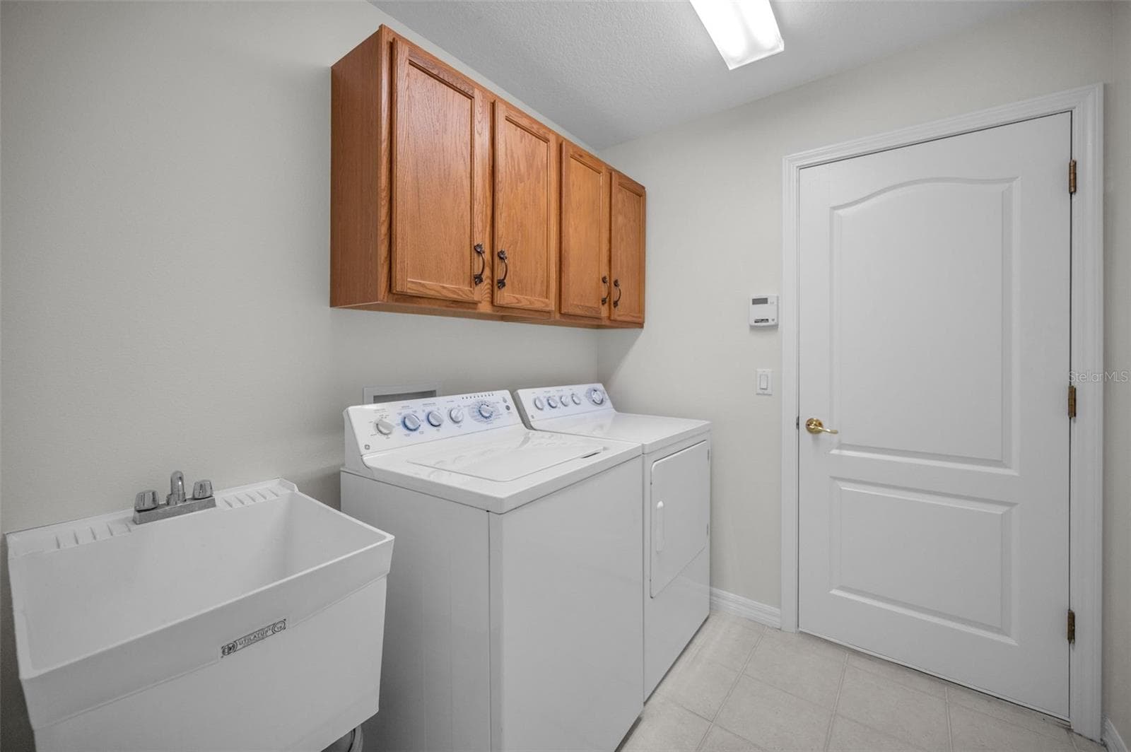 INTERIOR LAUNDRY ROOM W/ WASHER AND DRYER AND DOOR TO TWO CAR GARAGE - 12021 FERN TERRACE CT, TRINITY