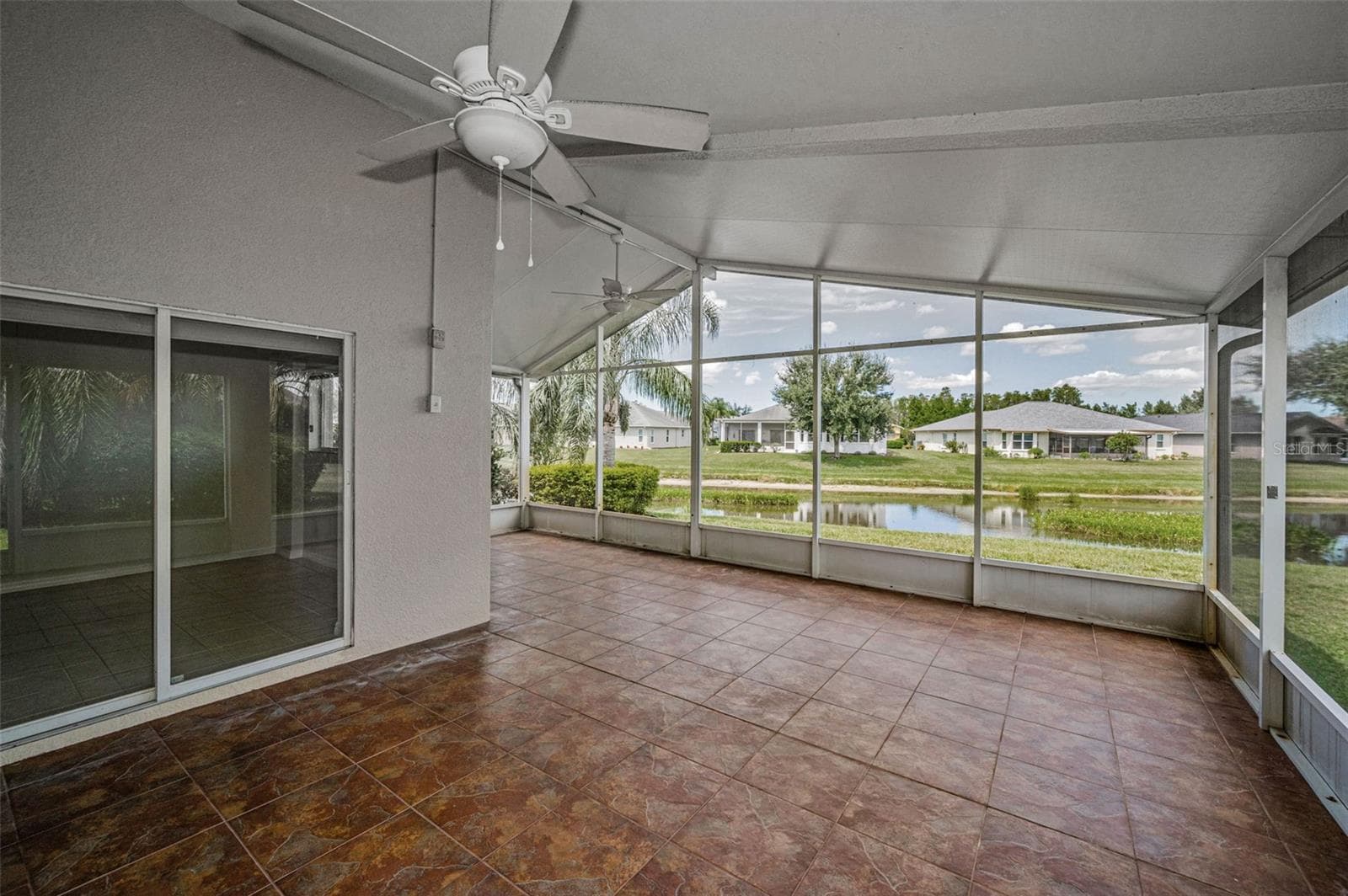 EXTERIOR ENLARGED SCREENED IN LANAI WITH TILED FLOORS AND CEILING FANS.. - 12021 FERN TERRACE CT, TRINITY